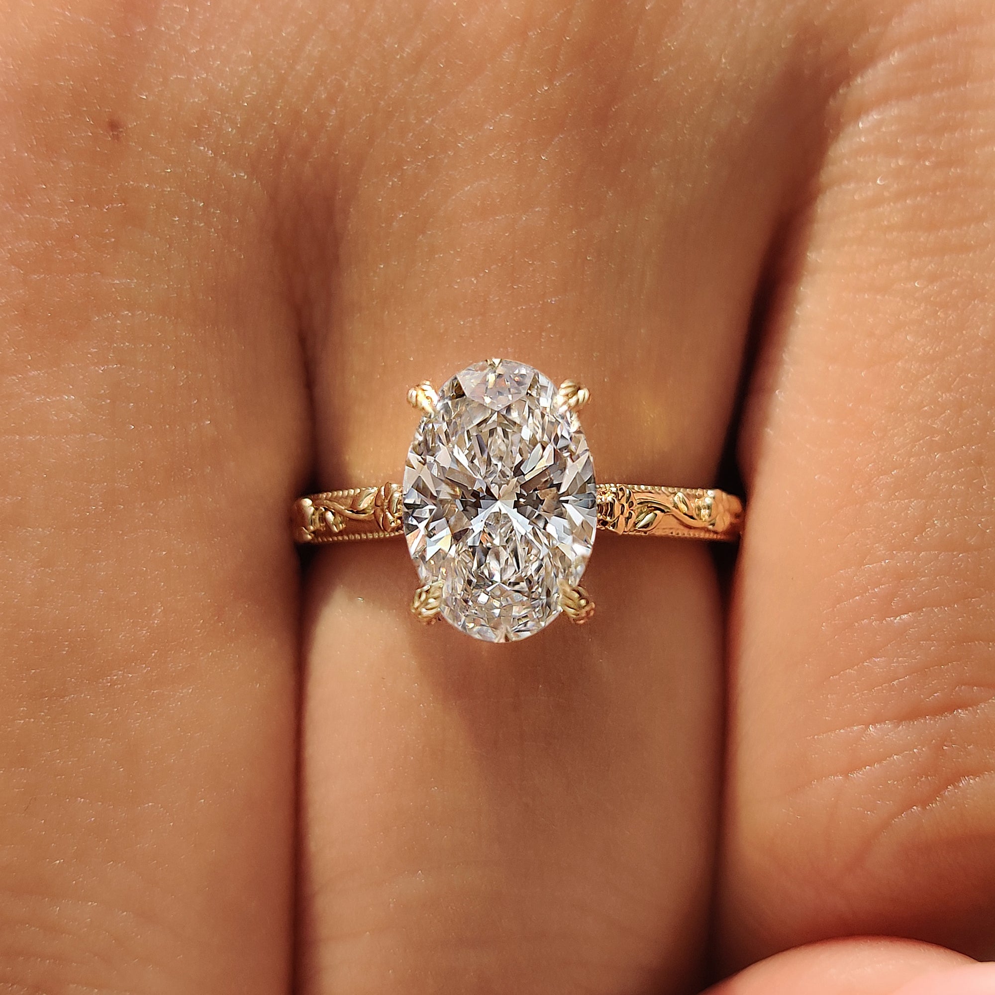 Oval engagement ring with round bridge accents.
