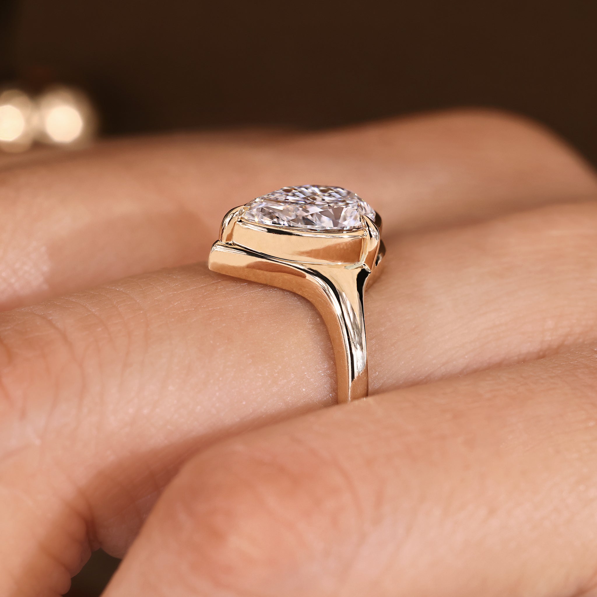 Pear cut diamond ring with bezel and handmade details.
