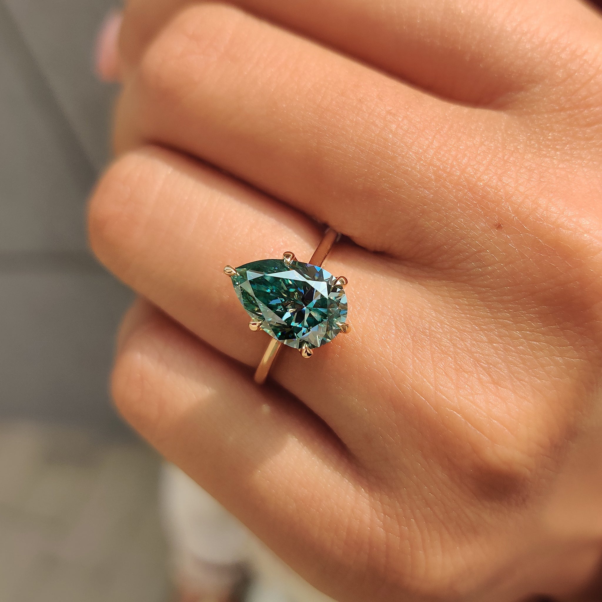 Handmade cyan blue pear moissanite ring.
