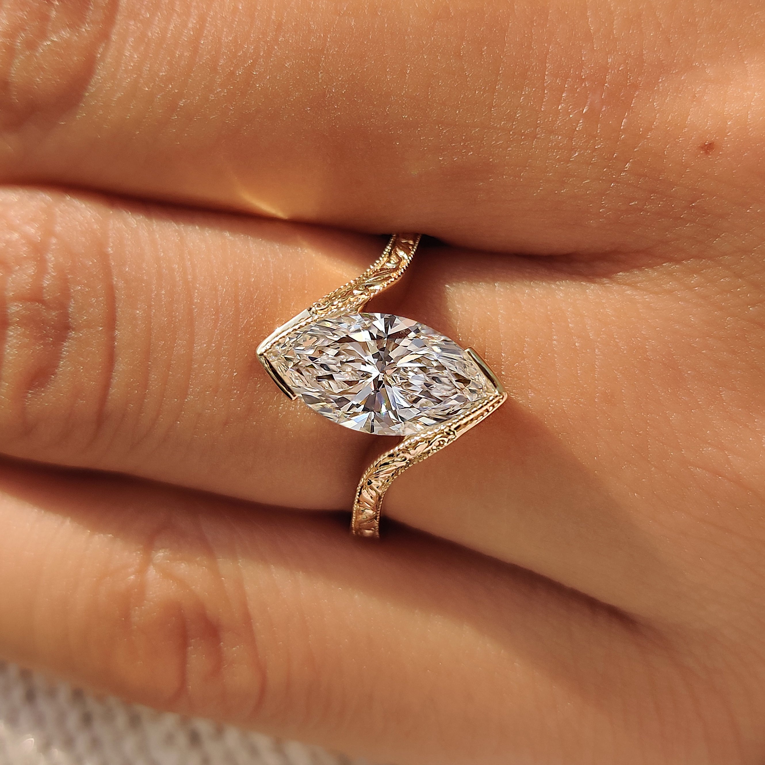 Yellow gold marquise solitaire ring with milgrain details.
