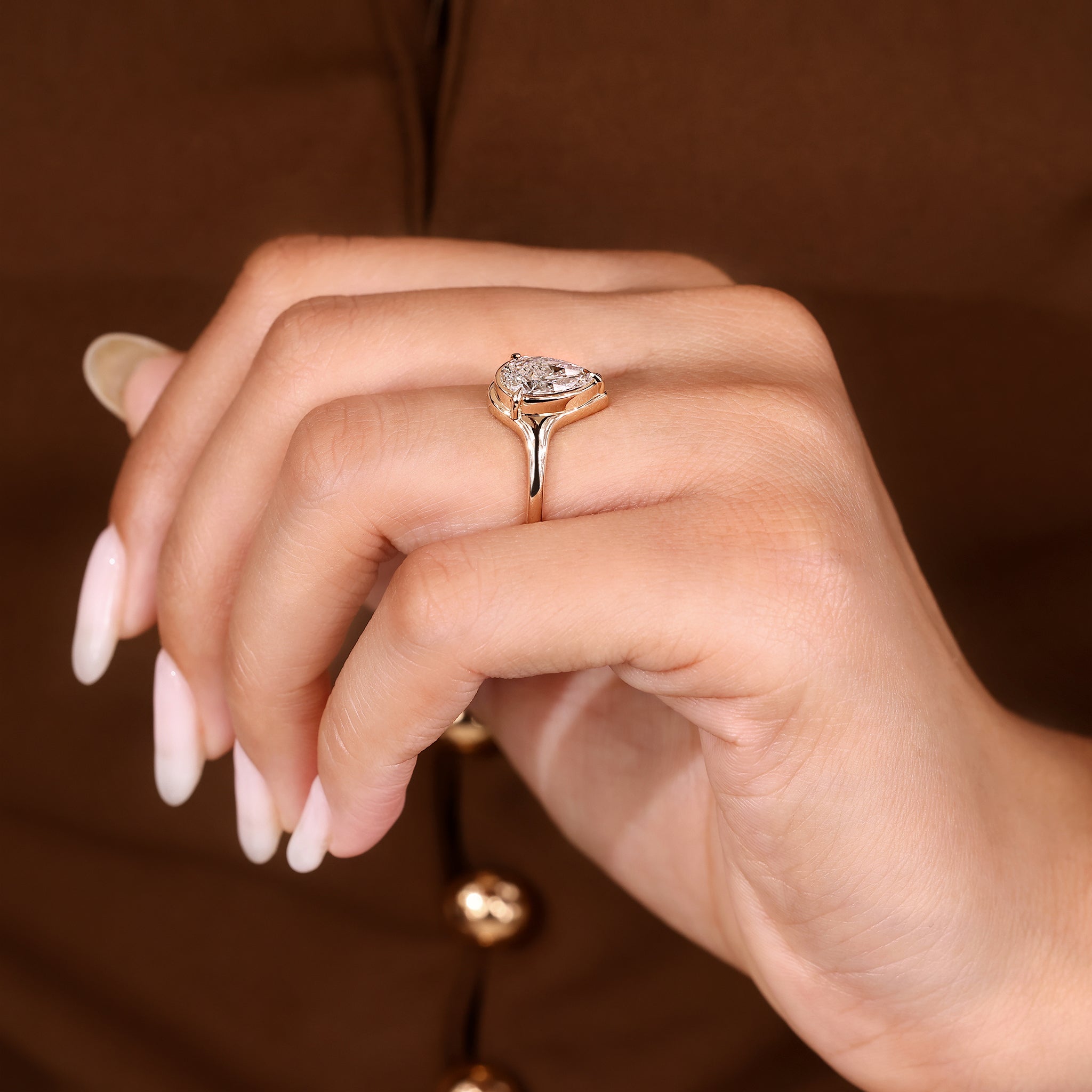 Lab grown pear cut diamond ring with tapered shank.
