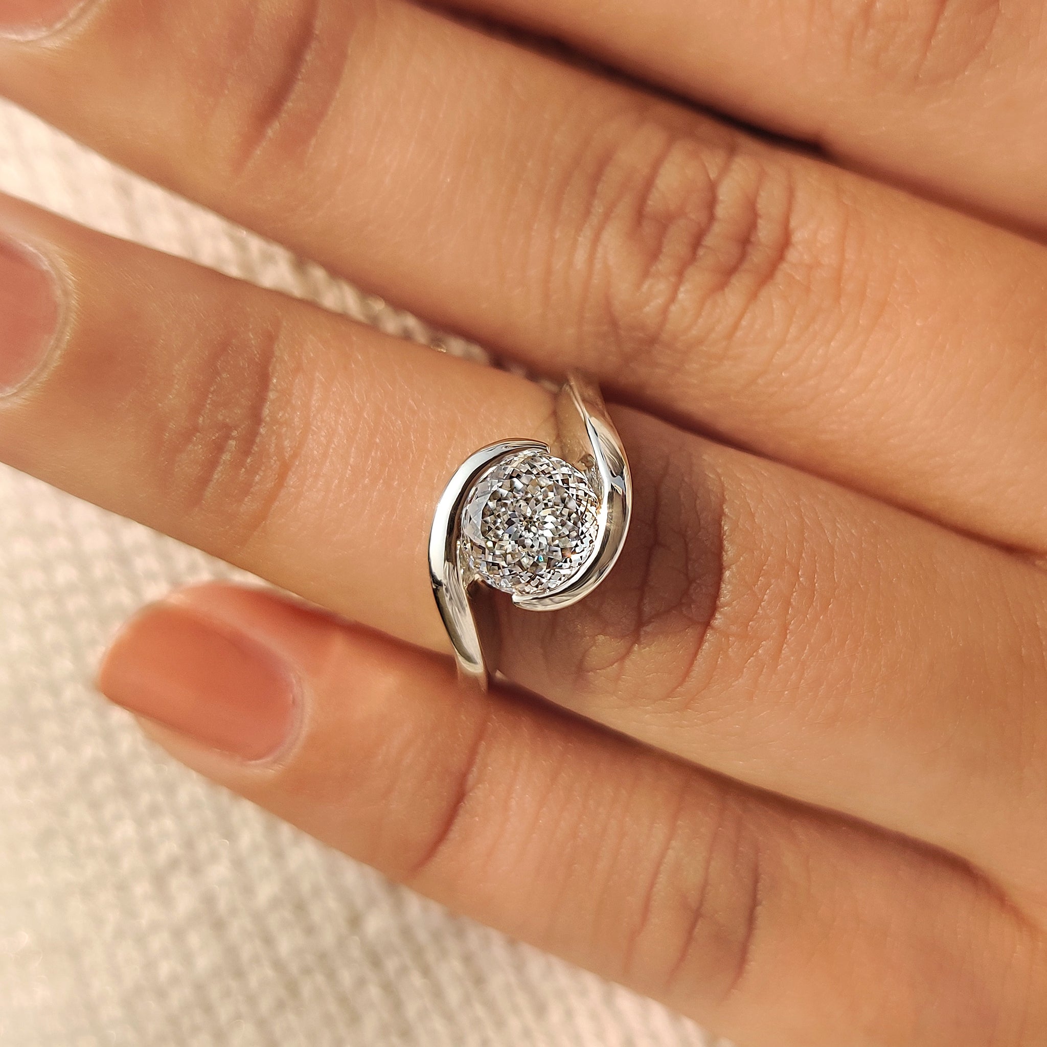 Portuguese lab diamond ring with solitaire and bypass design.
