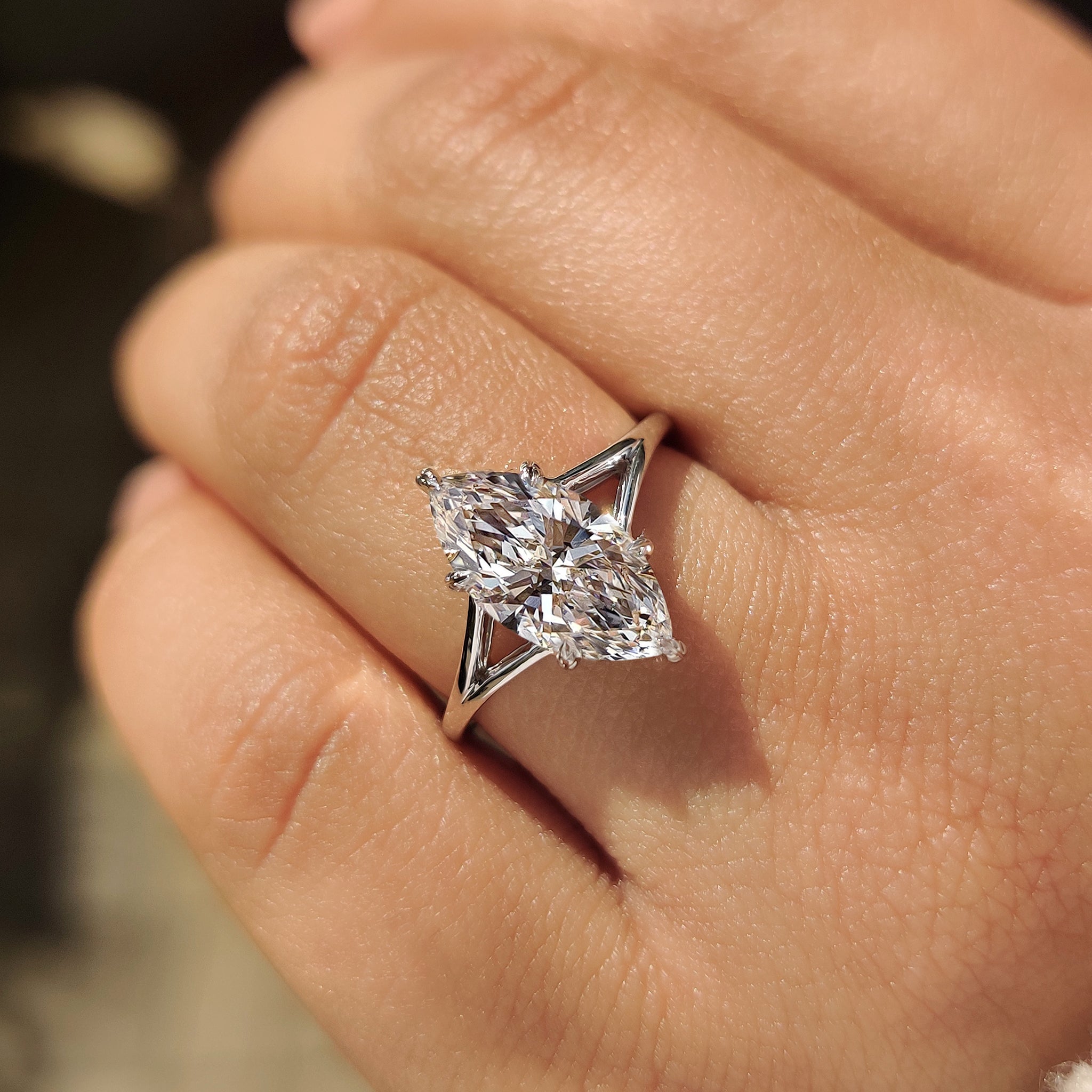 Six leaf style prong holds marquise solitaire diamond ring.
