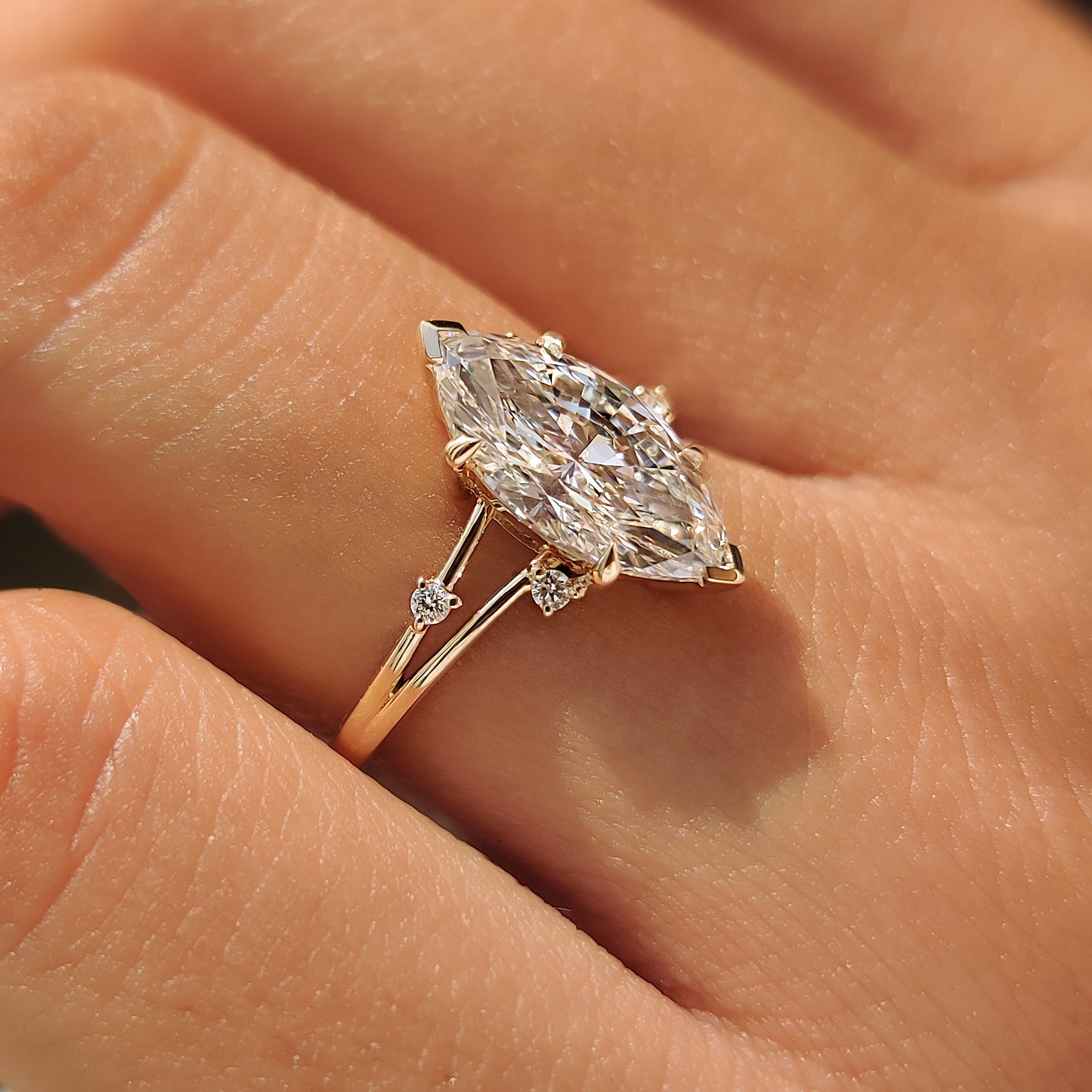 Side view of a marquise split shank ring with round side stones.
