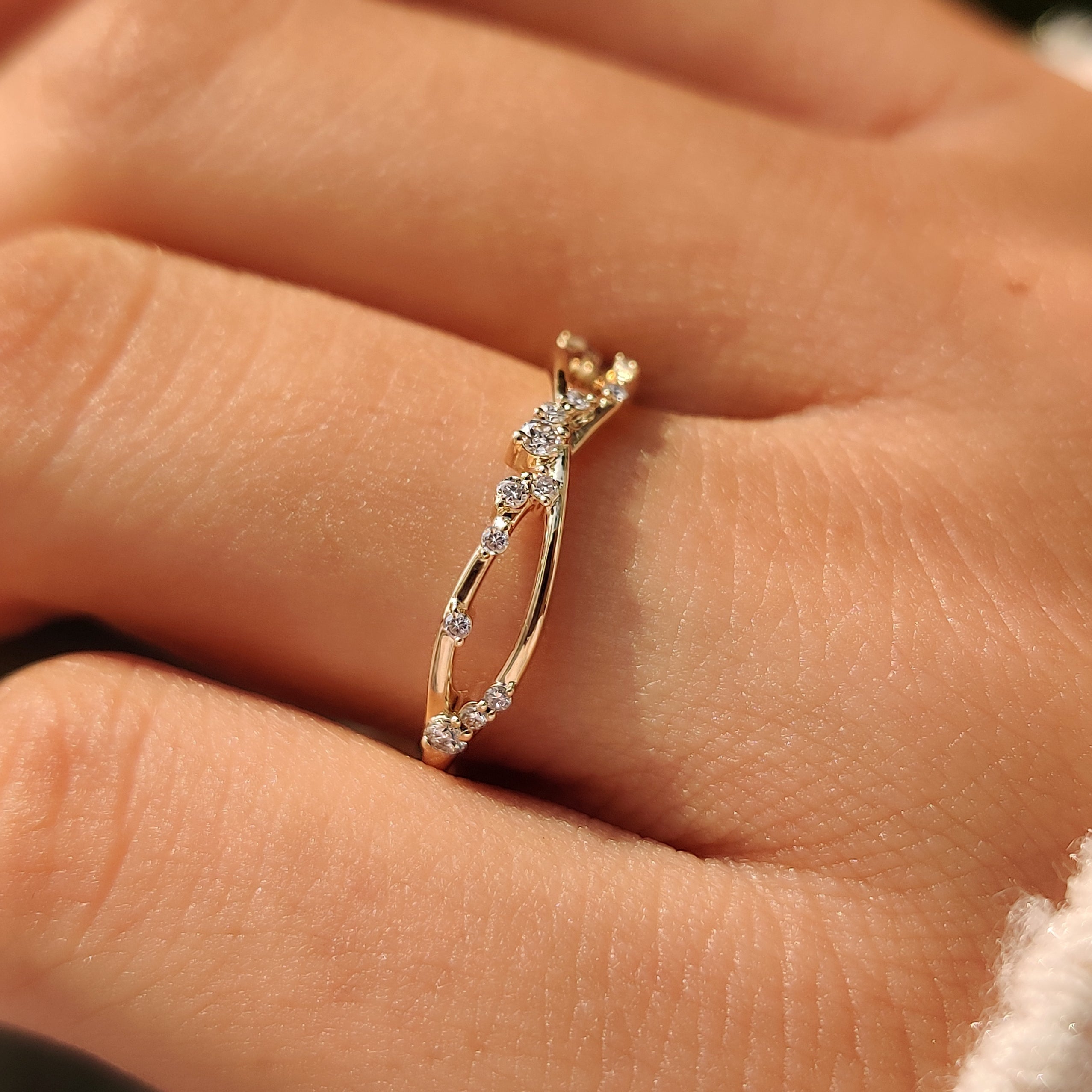 Twisted yellow gold band with a row of round diamonds.
