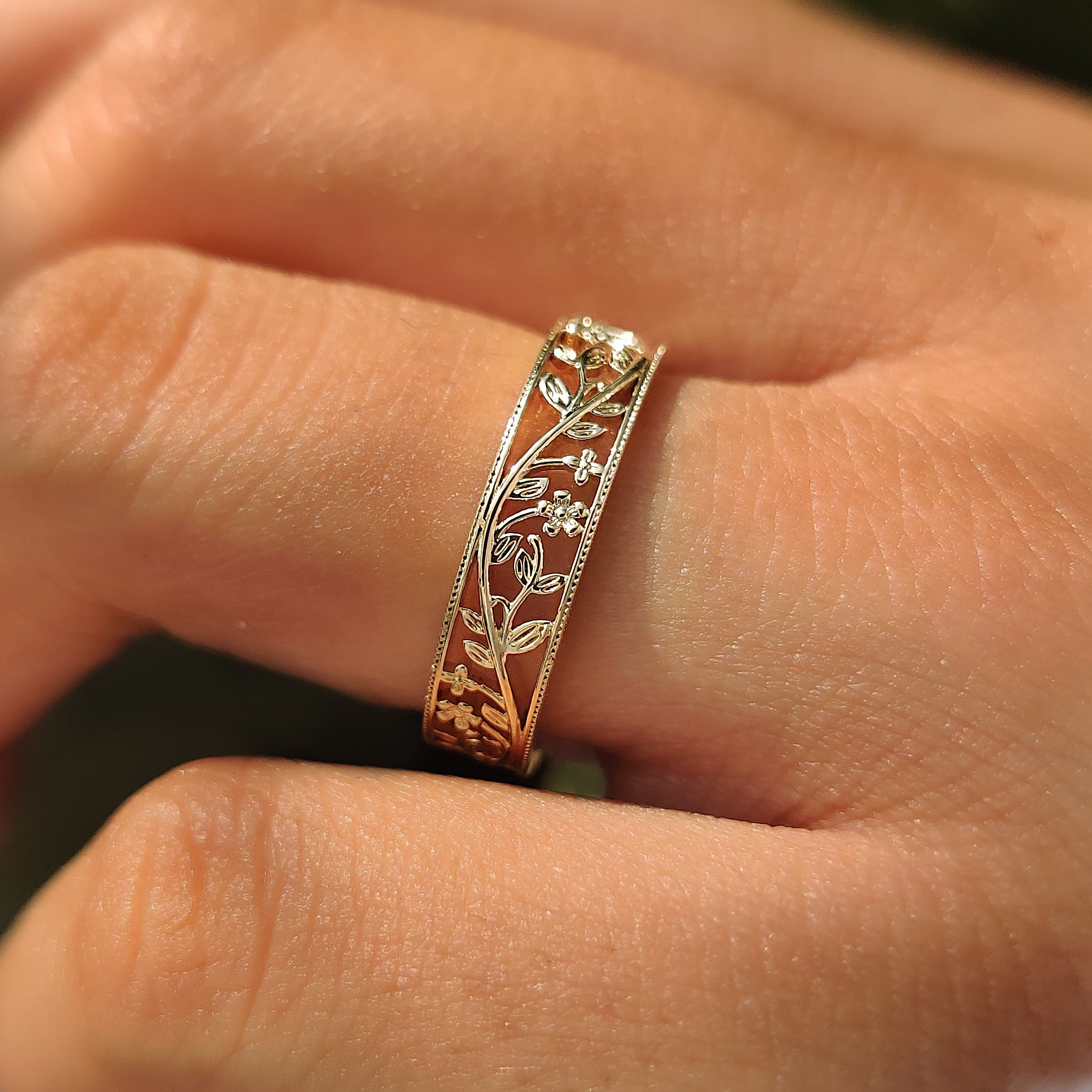 Pointed leaves and winding vines on a flower wedding band.
