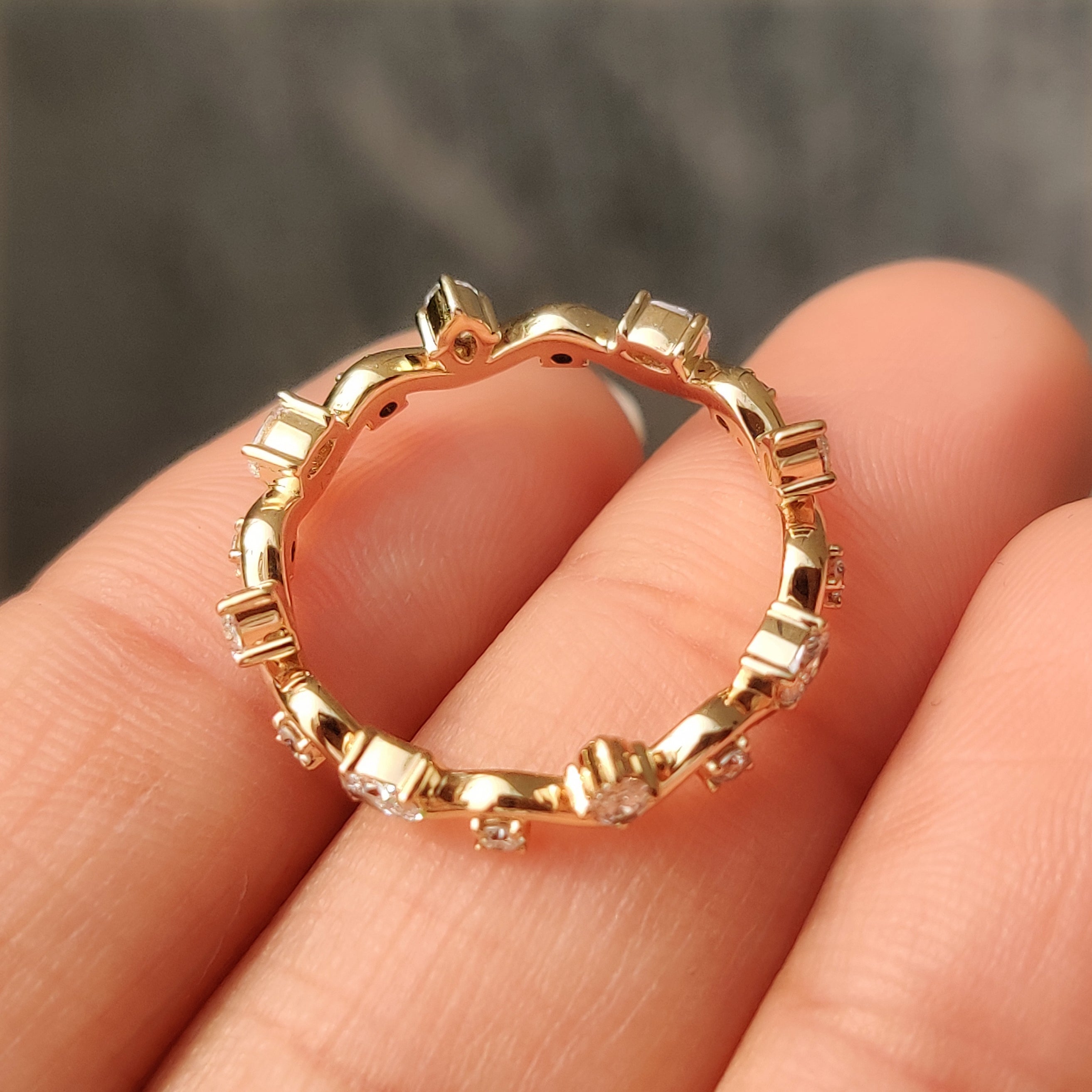 Yellow gold eternity band with oval and round diamonds.
