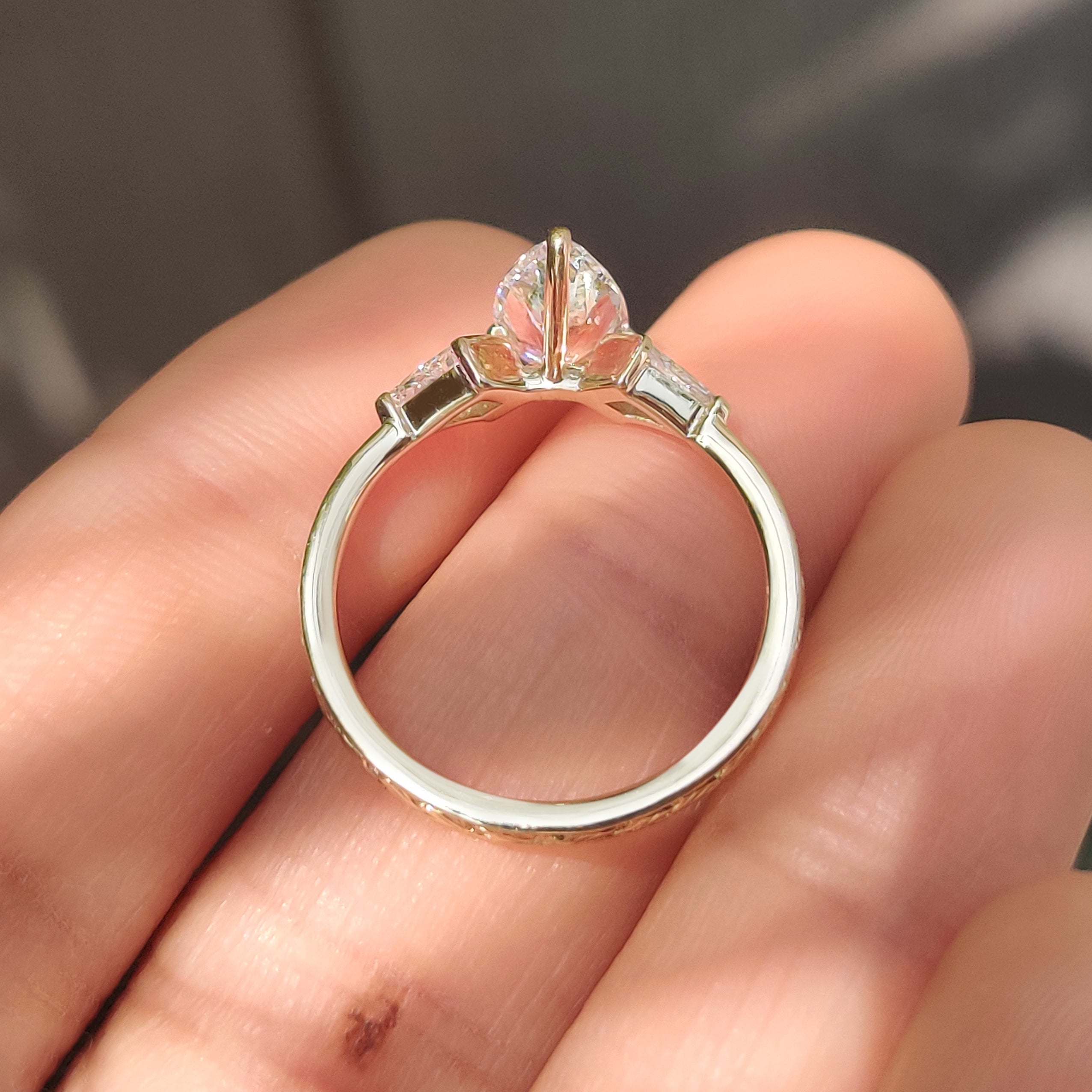 Handmade three stone ring with kite cut side diamonds.
