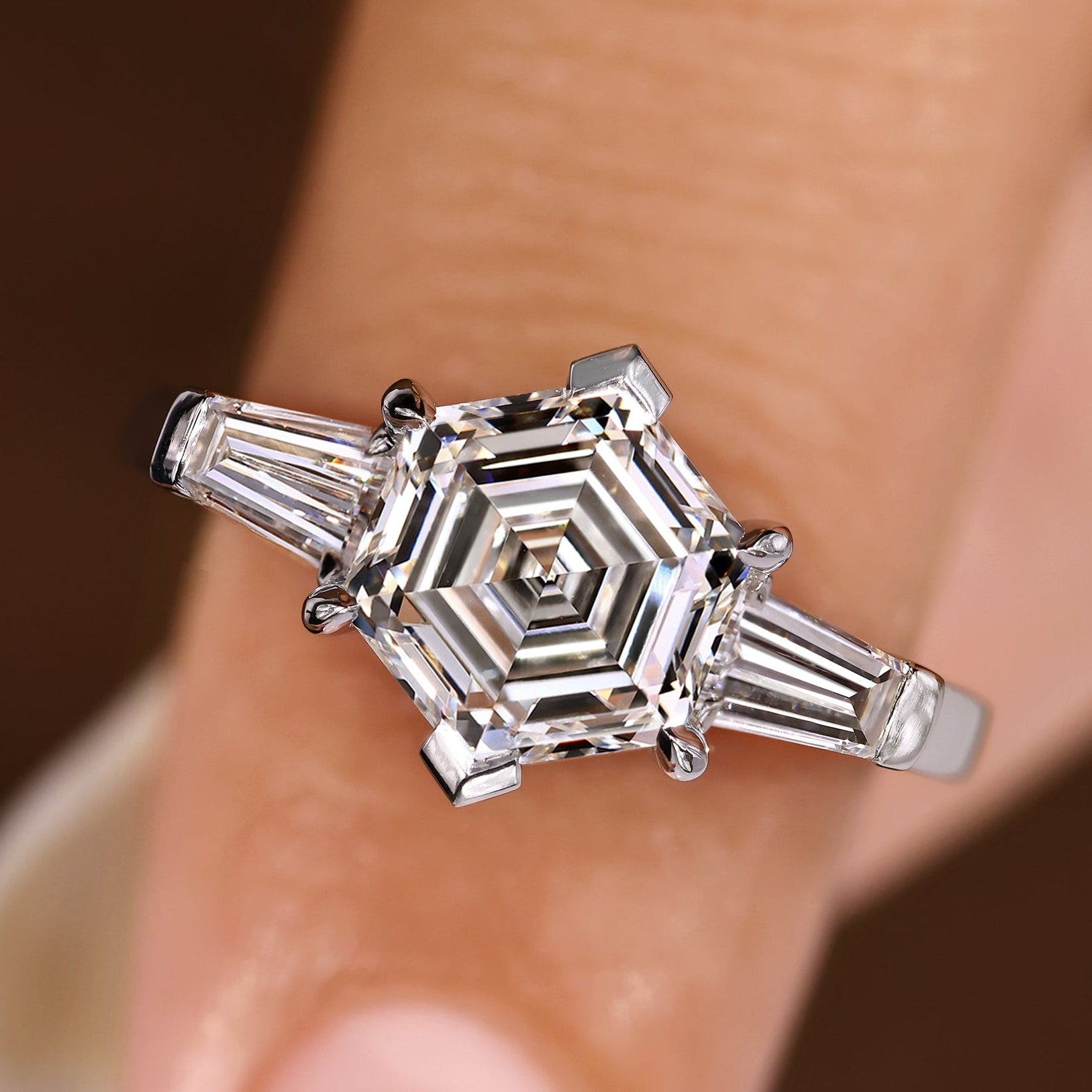 Three diamond ring with hexagon center and baguette sides.

