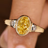 Oval cut engagement ring with light yellow center diamond
