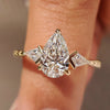 Three diamond ring with pear center and kite sides.
