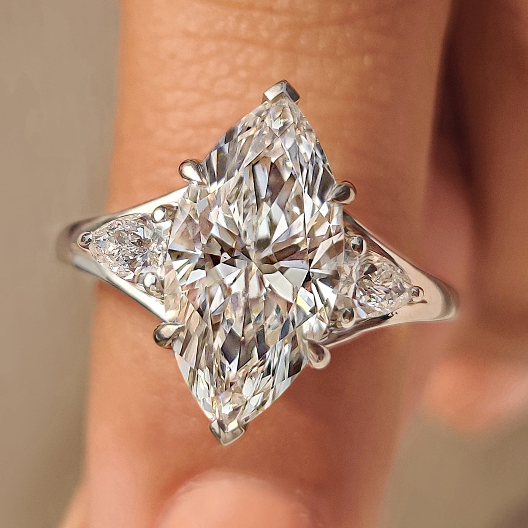 Marquise diamond ring with pear side stone in three stone design

