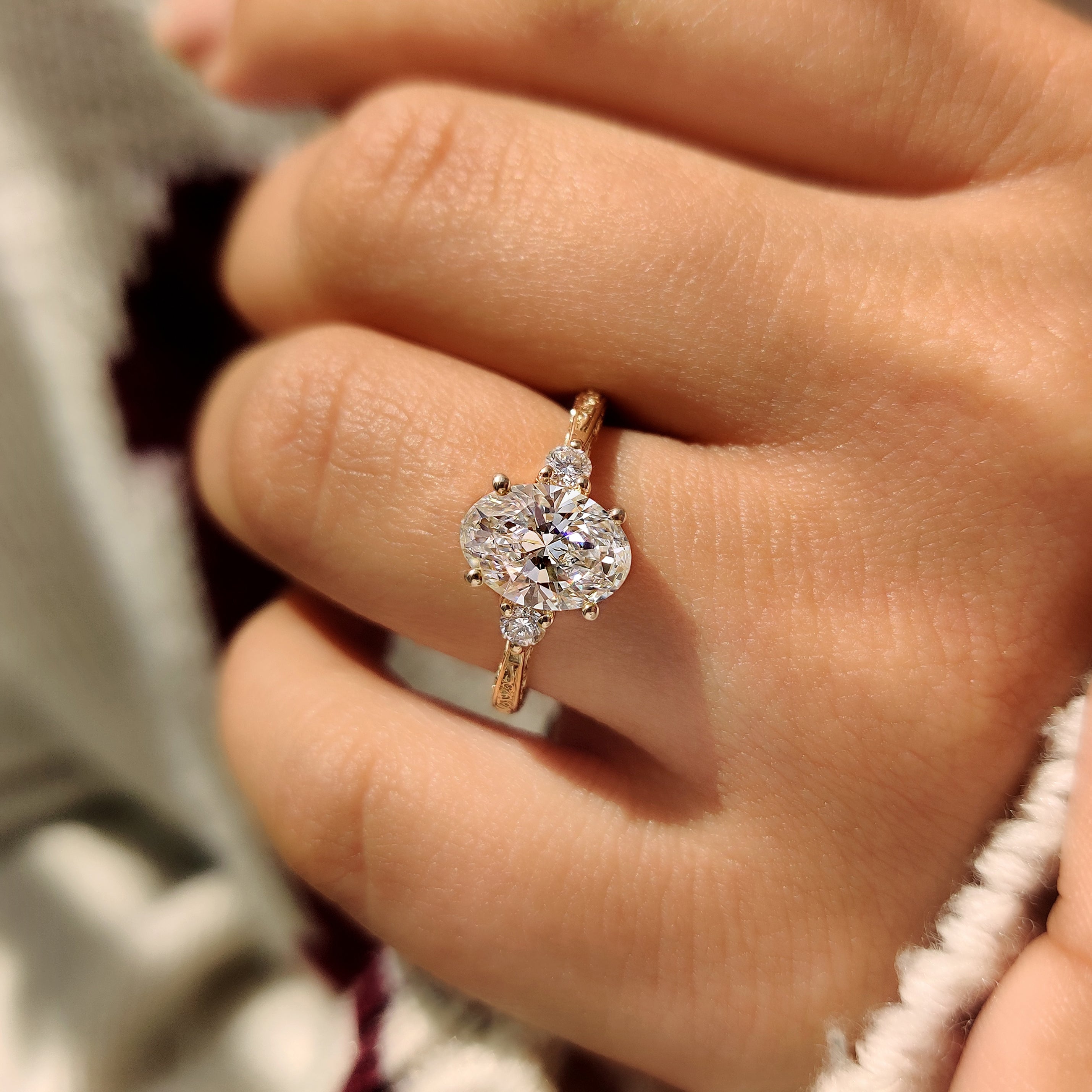 Handmade oval diamond ring with engraved shank details.
