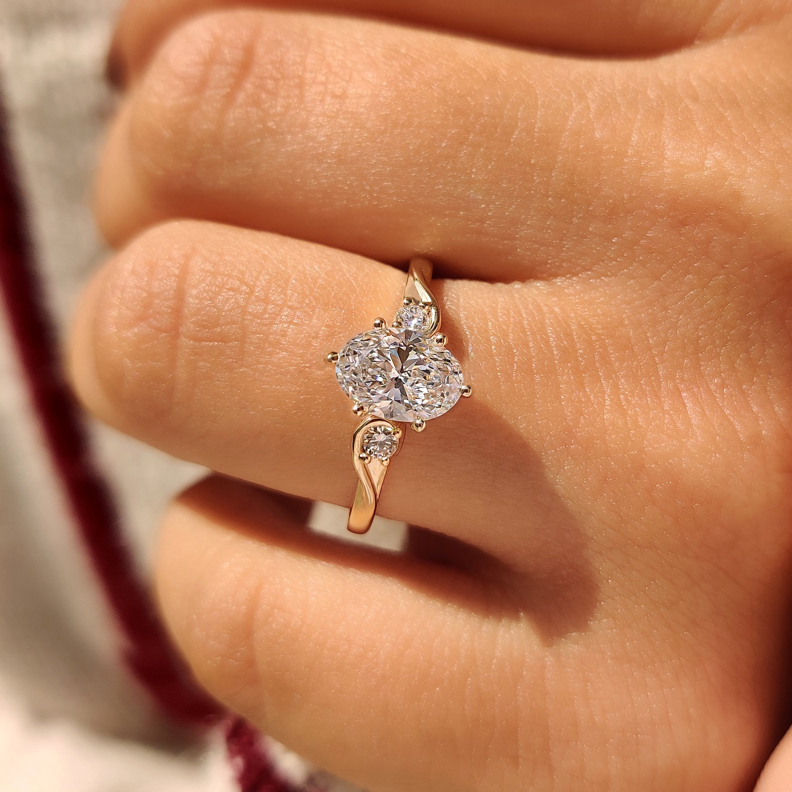 Oval cut diamond ring with round side stone accents
