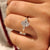 Oval cut diamond ring with round side stone accents
