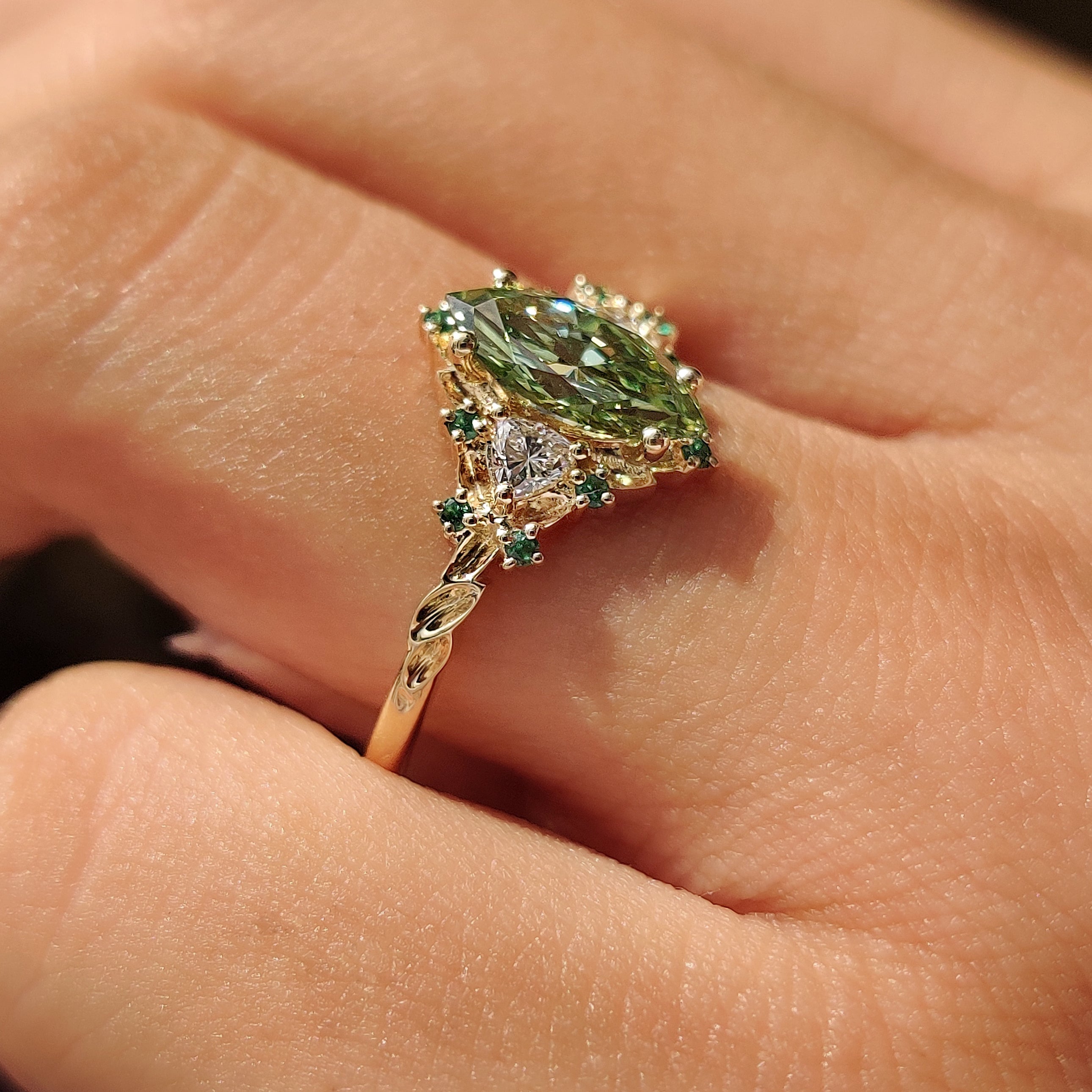 Green marquise center diamond with trillion side stones.
