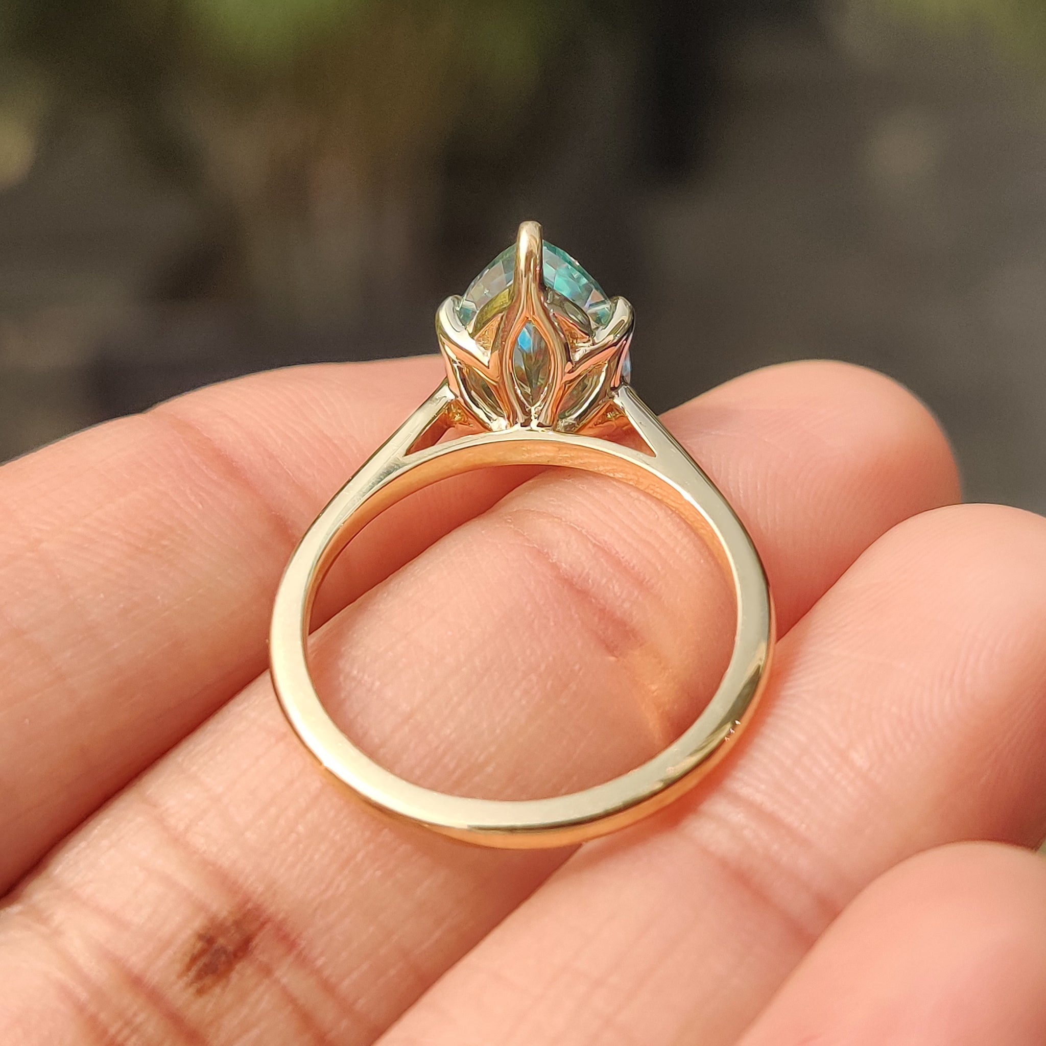 Cyan blue moissanite ring with tulip basket.
