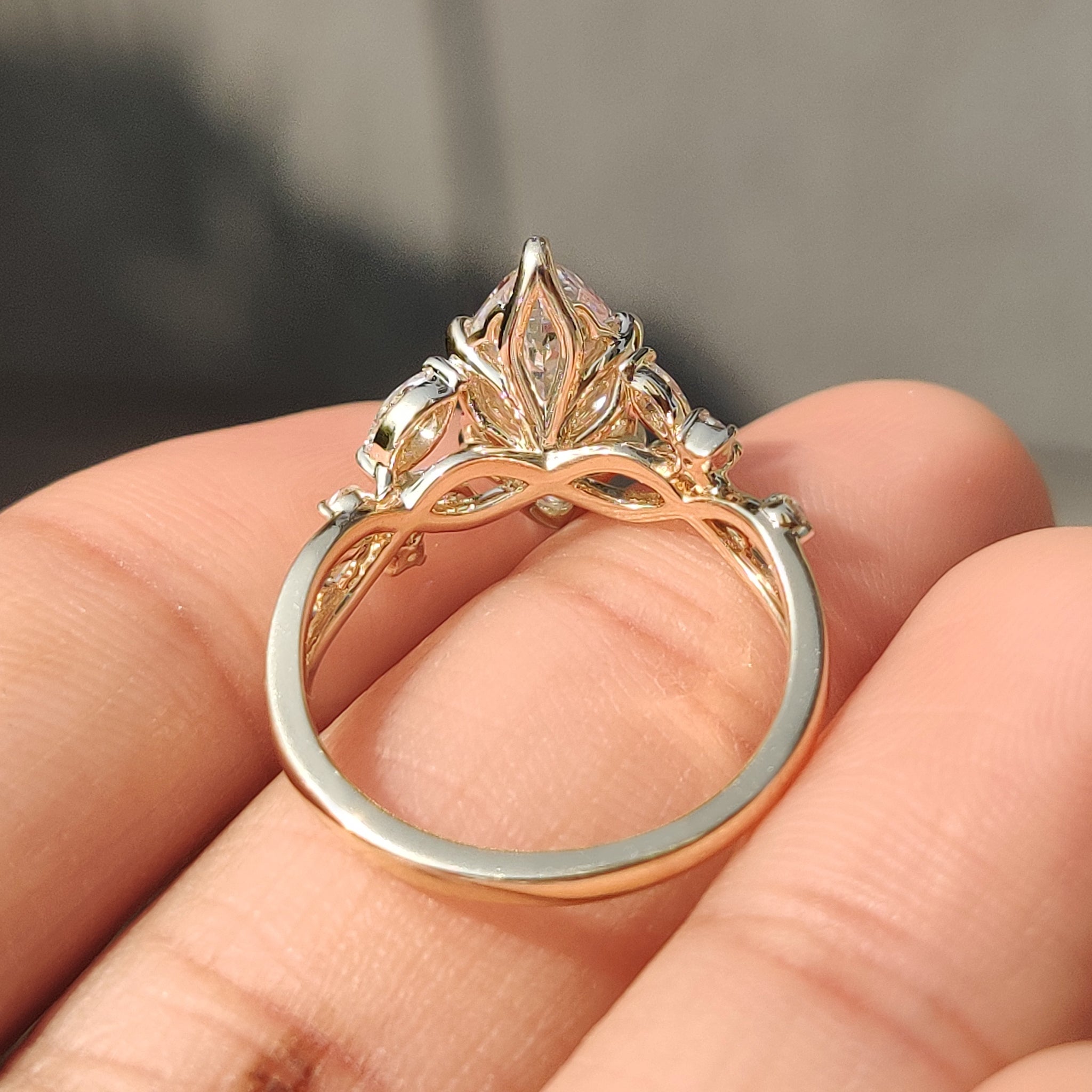 Tulip setting marquise engagement ring with round side stones.
