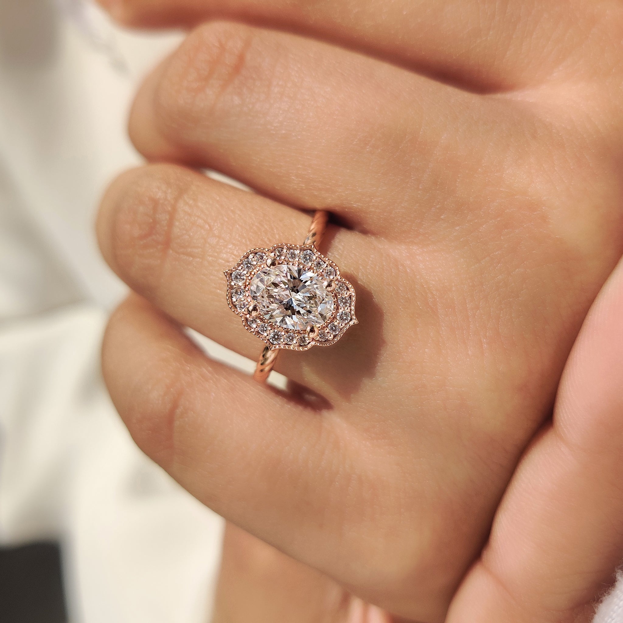 Oval diamond engagement ring with round cut halo and milgrain
