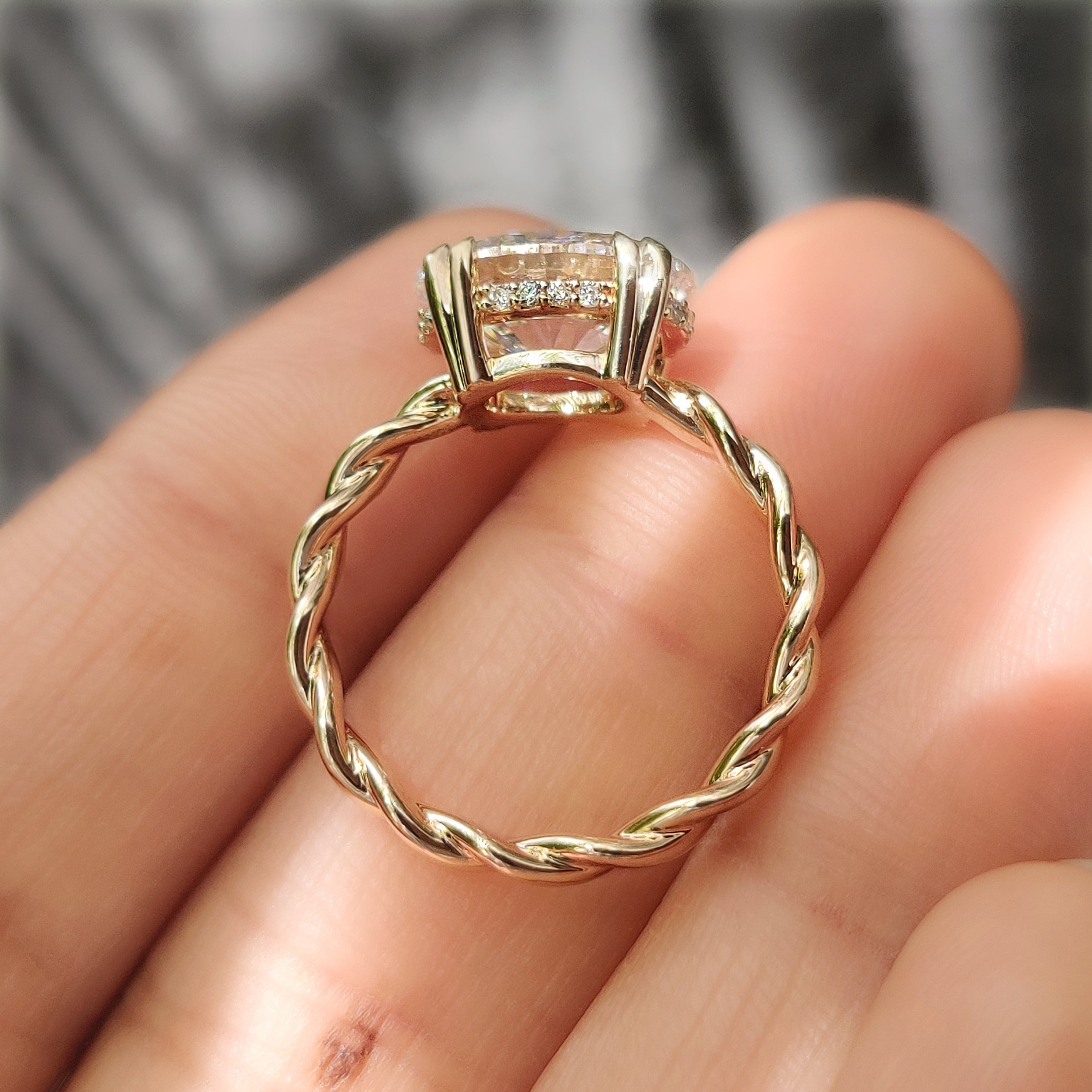 Oval engagement ring with round hidden halo and twist band
