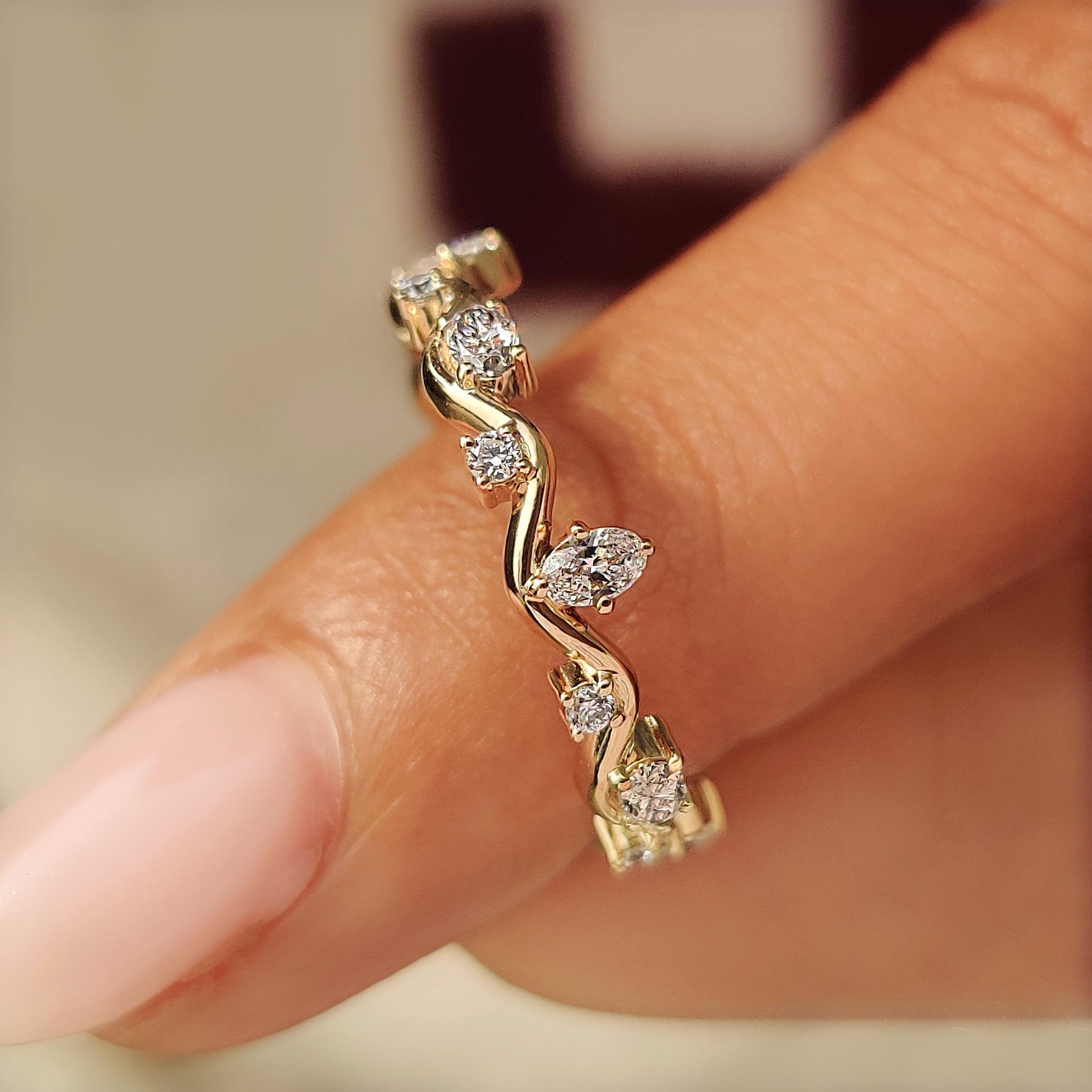 Close-up of four prong settings on a wave diamond band.
