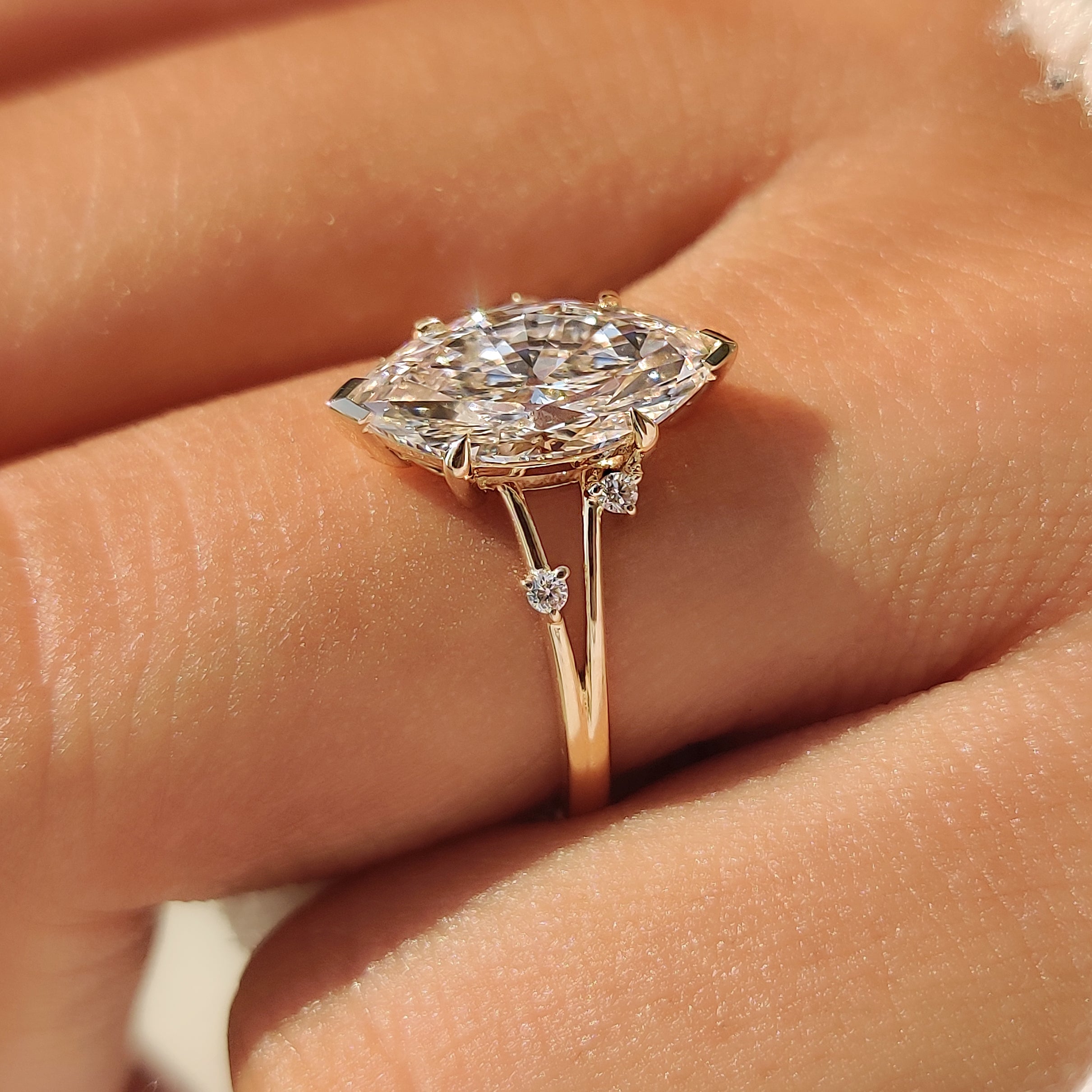 Marquise engagement ring with round diamonds on both sides.
