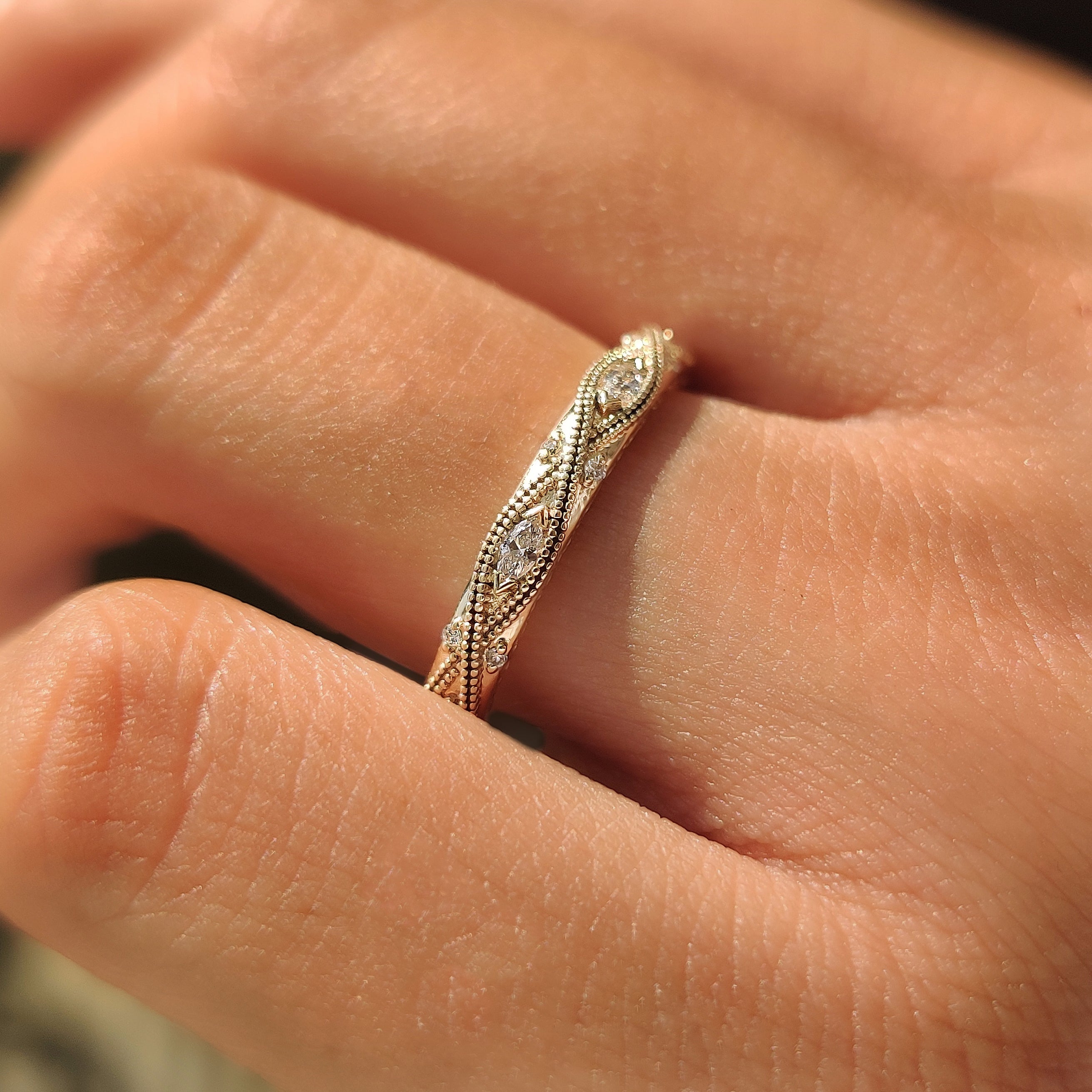 Marquise diamonds set between round diamonds on a wedding band.
