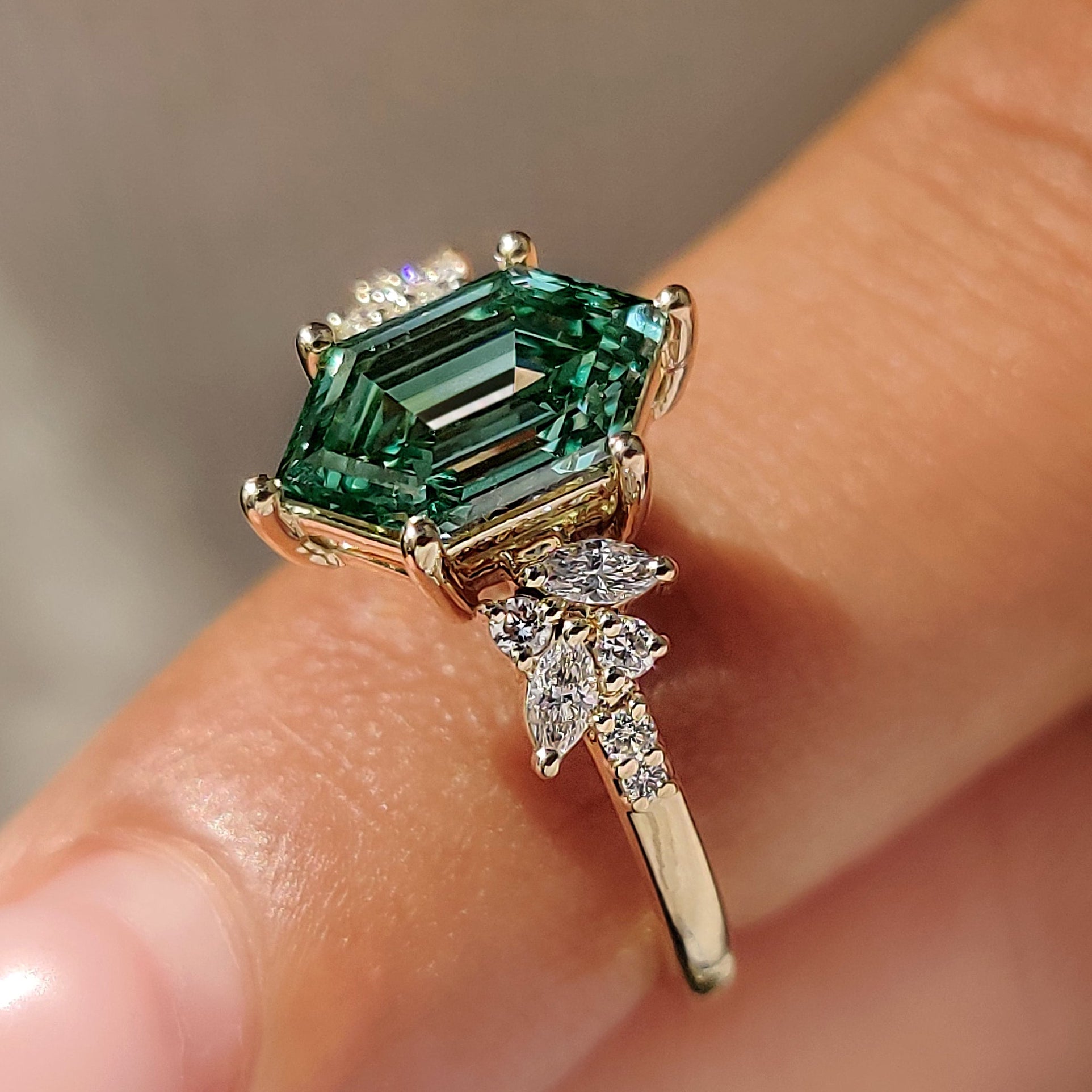 Green hexagon ring with marquise side stones.
