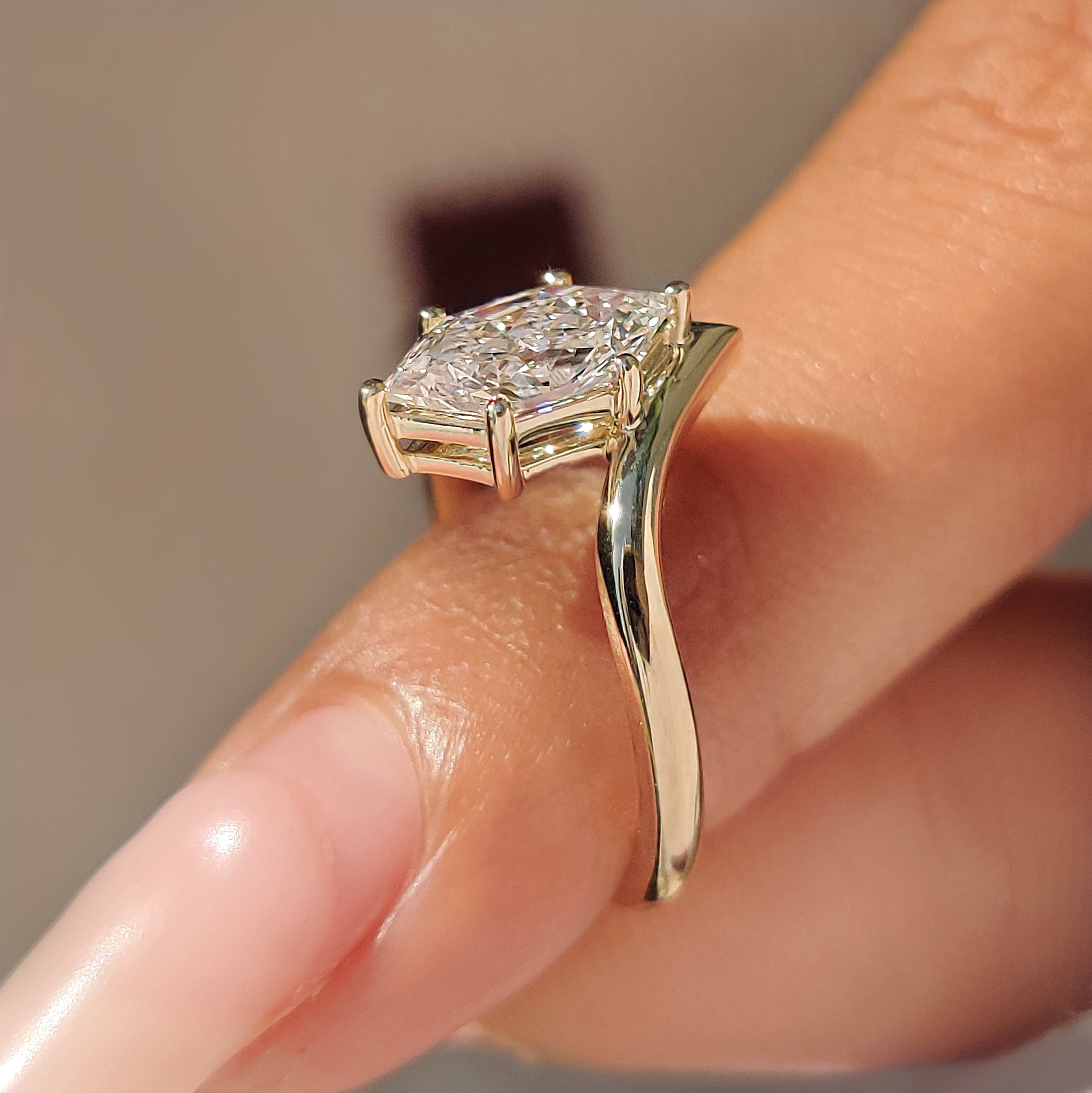 V shape setting supporting a Dutch marquise center diamond.

