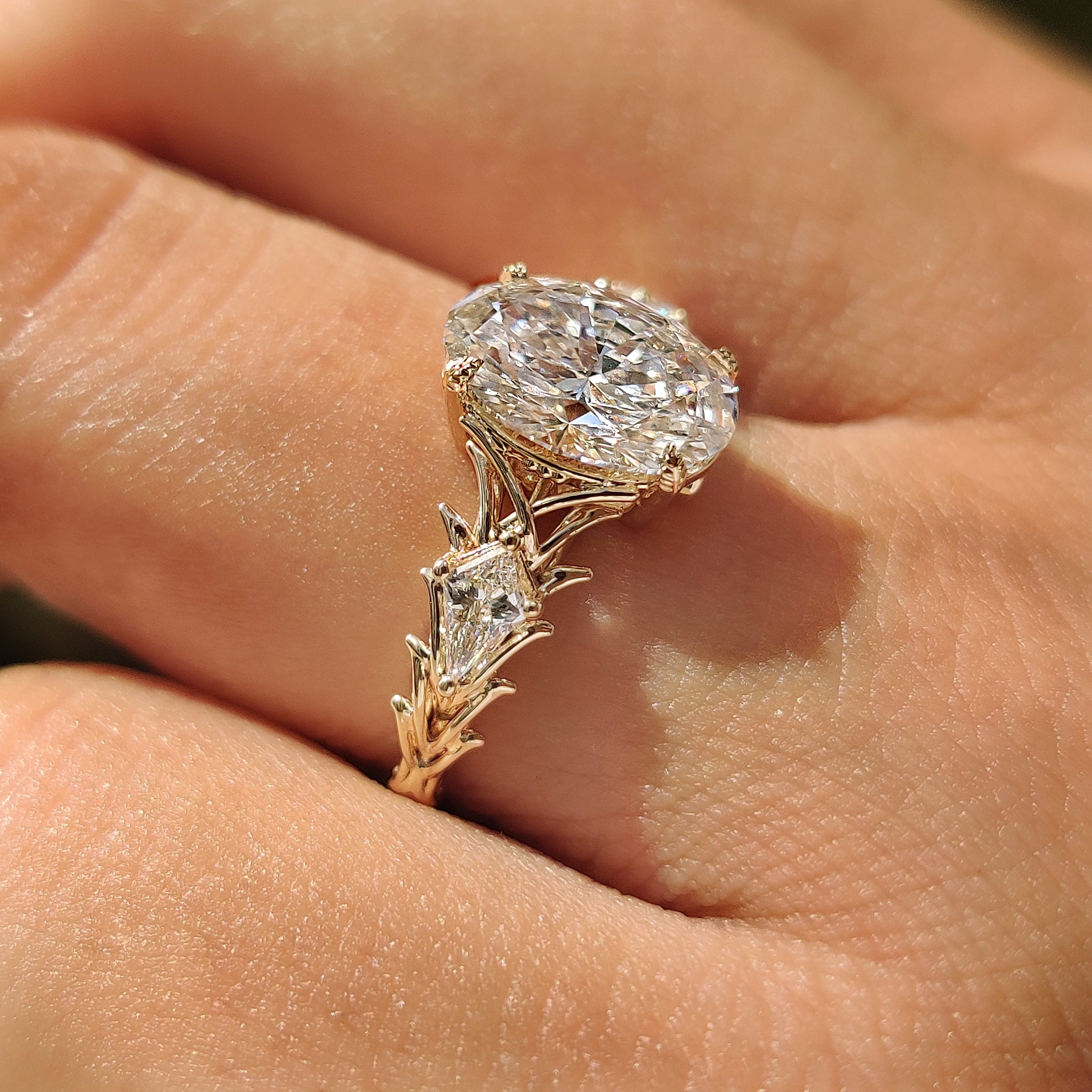 Kite side stone ring with oval center diamond
