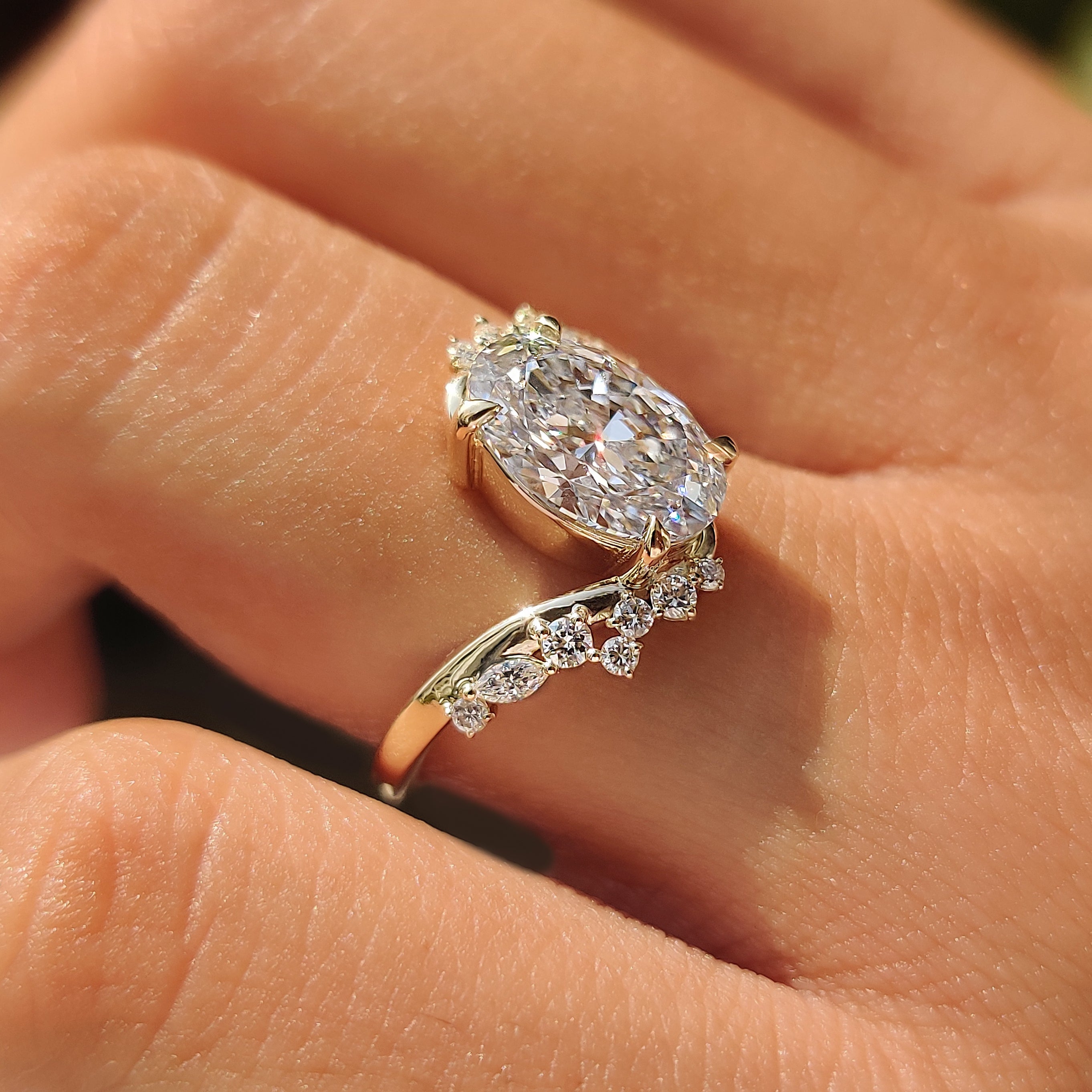 Round side stones paired with an oval cut center diamond.
