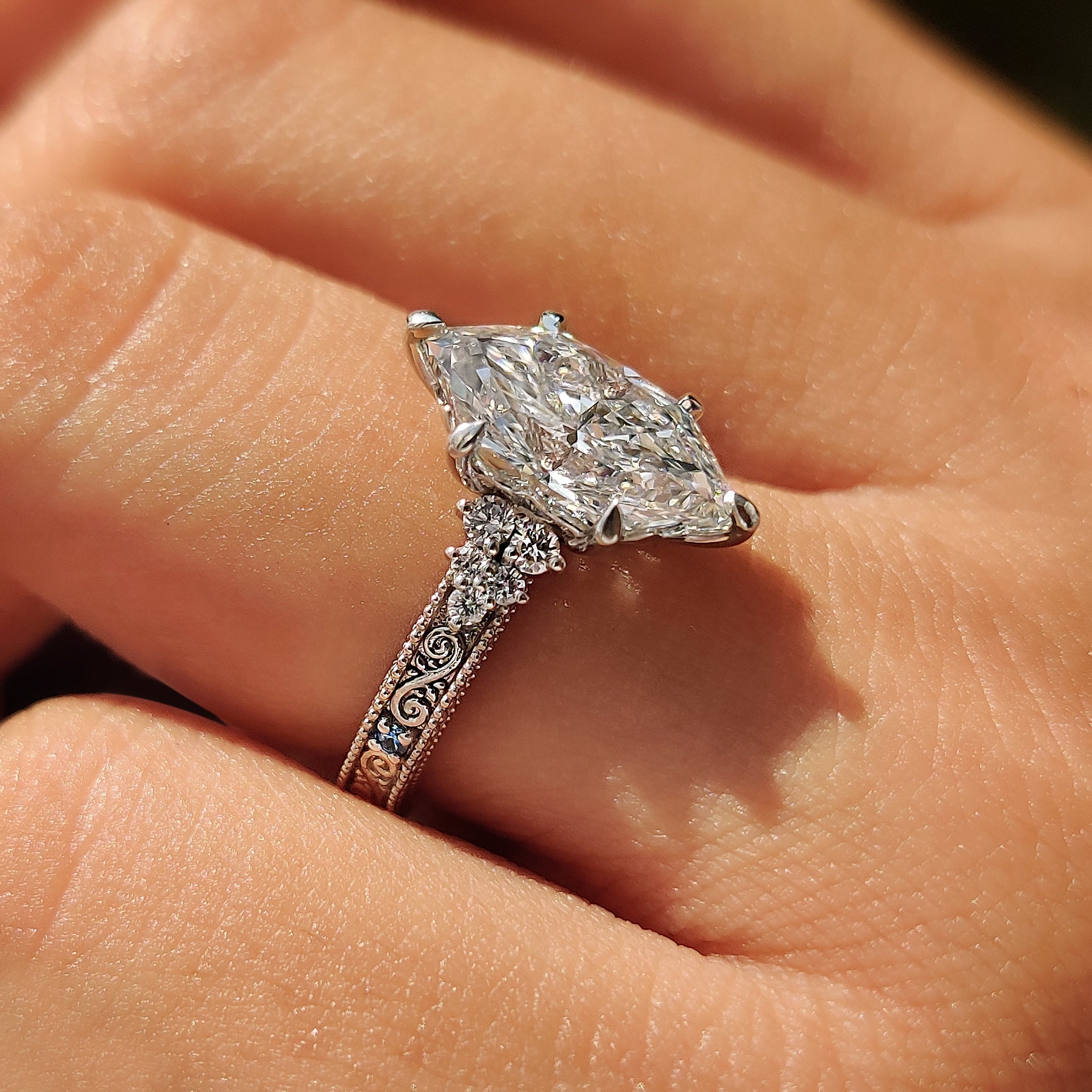 Dutch marquise center diamond with aquamarine birthstones and round side stones.
