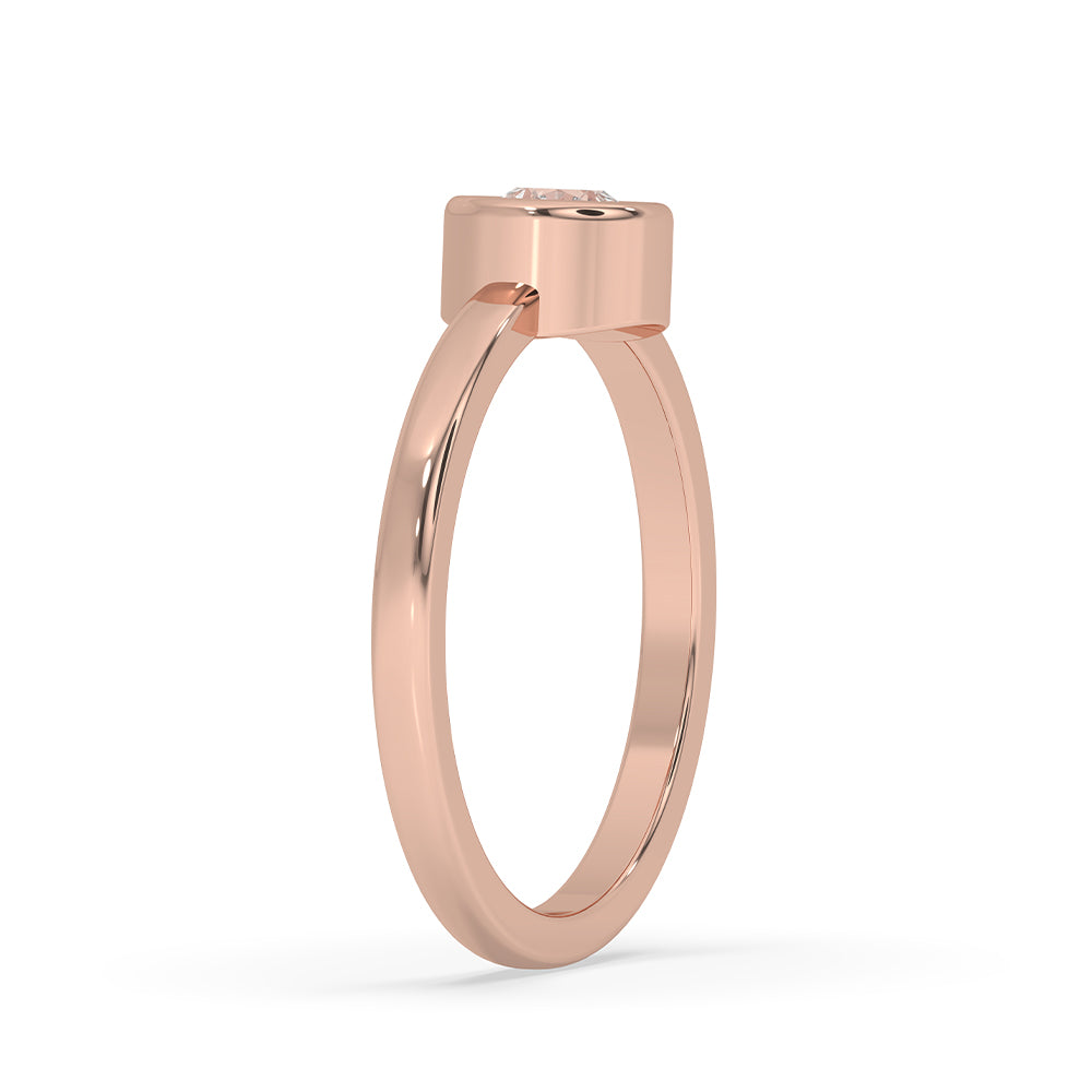Rose gold diamond ring placed beside matching earrings.