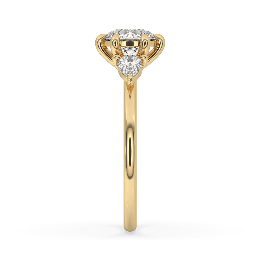 Prong setting ring featuring a 3 stone pear diamond design on yellow gold
