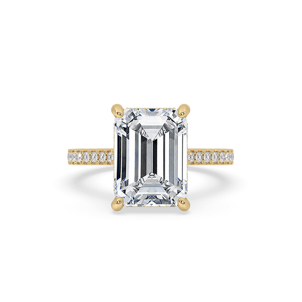 Gold emerald cut engagement ring in pave setting.