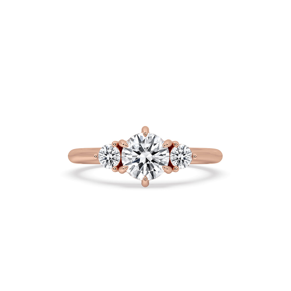 3 stone round diamond ring with rose gold band.
