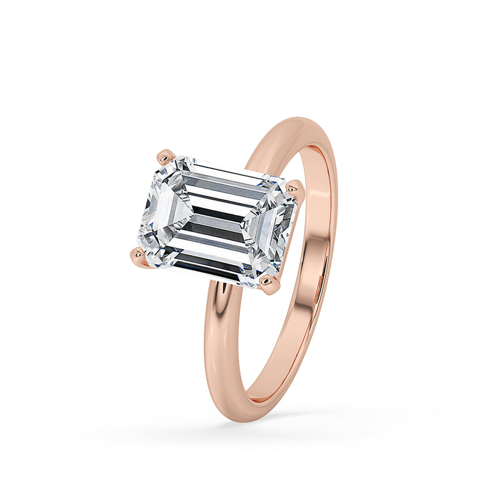 Rose gold ring displayed on a marble surface.