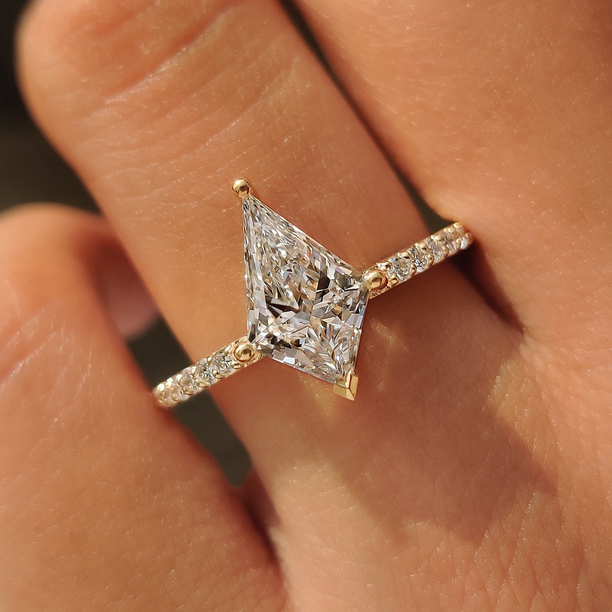 Round diamond accents set along a yellow gold engagement ring.