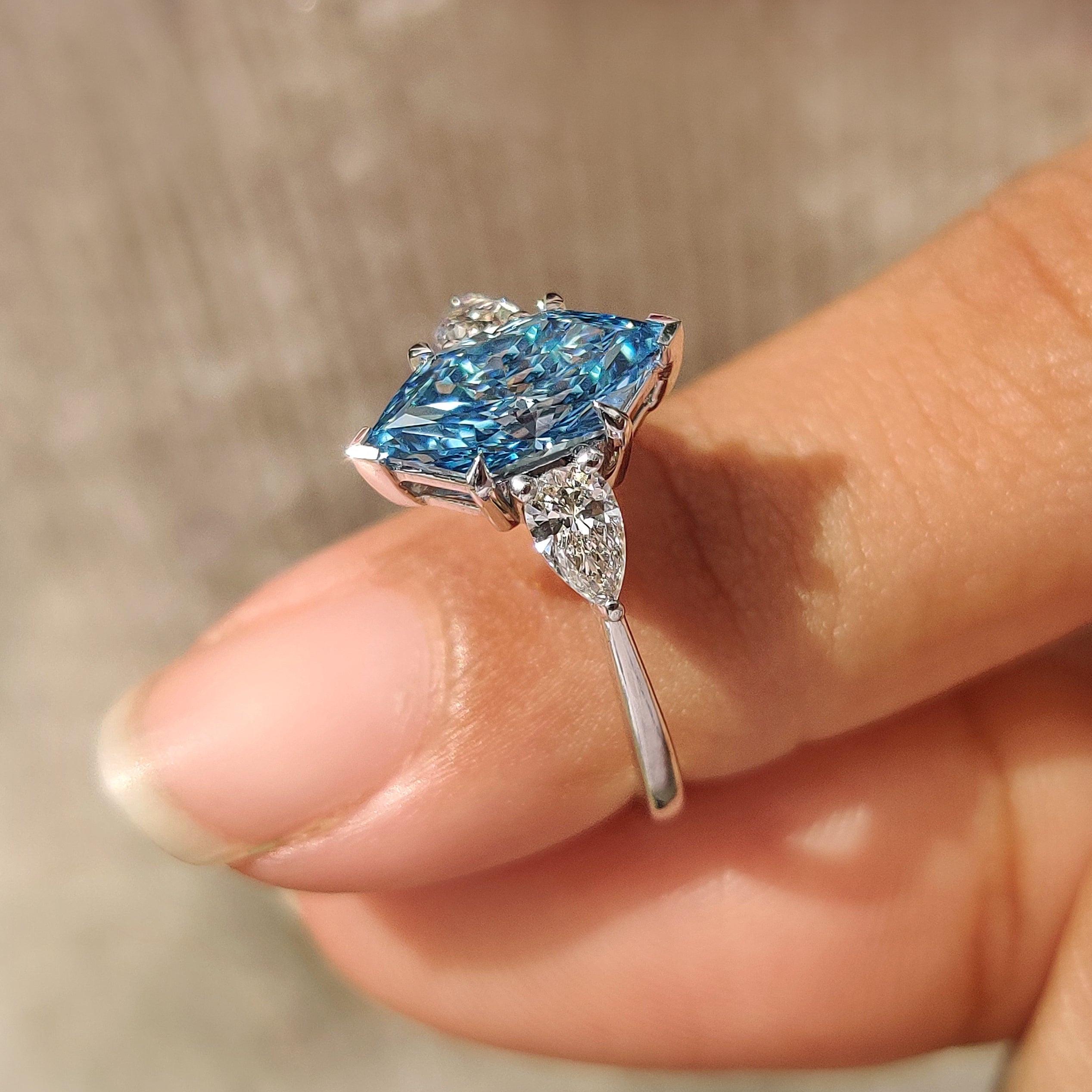 Lab grown diamond three stone ring with blue dutch marquise center stone
