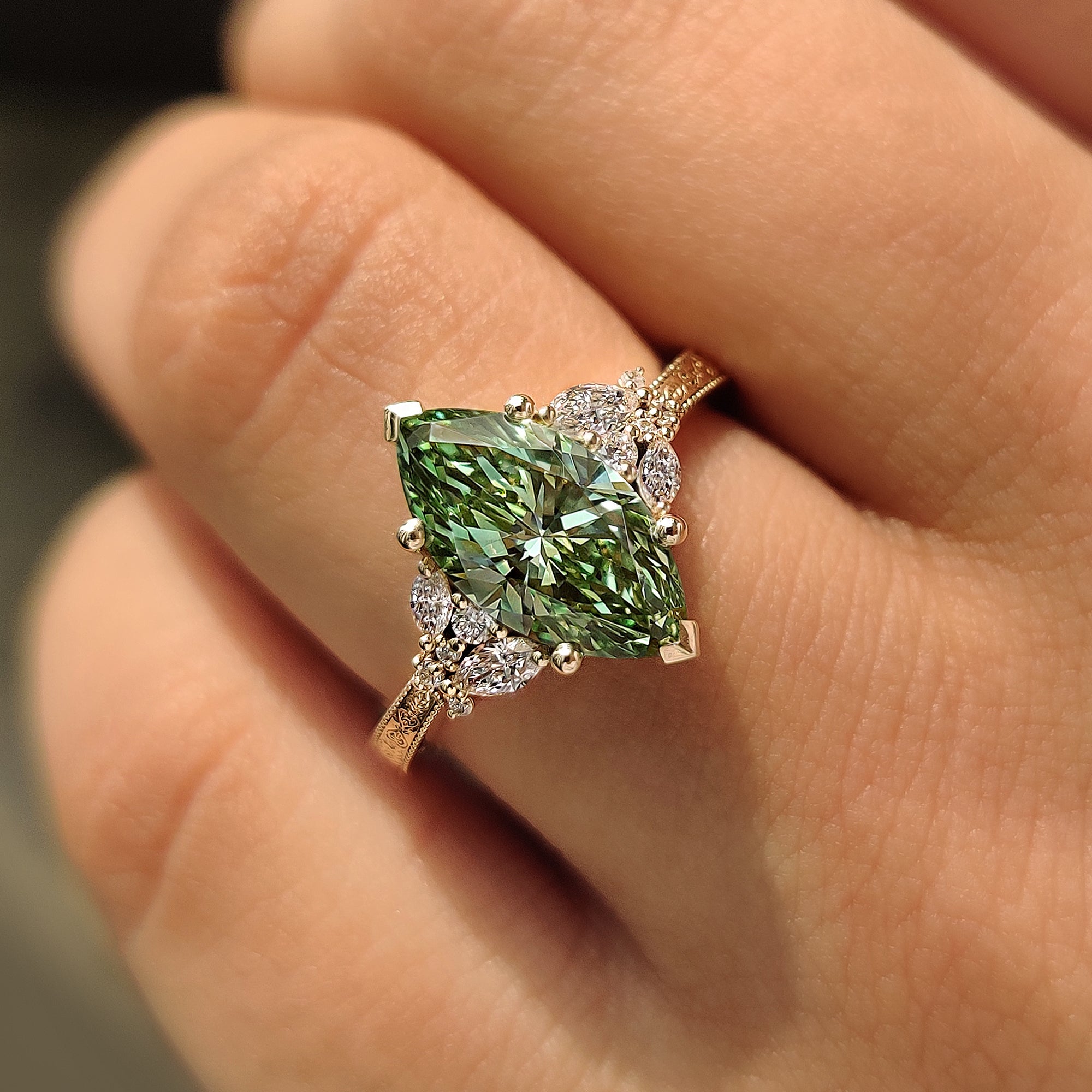 Green marquise cluster ring with four prong setting.
