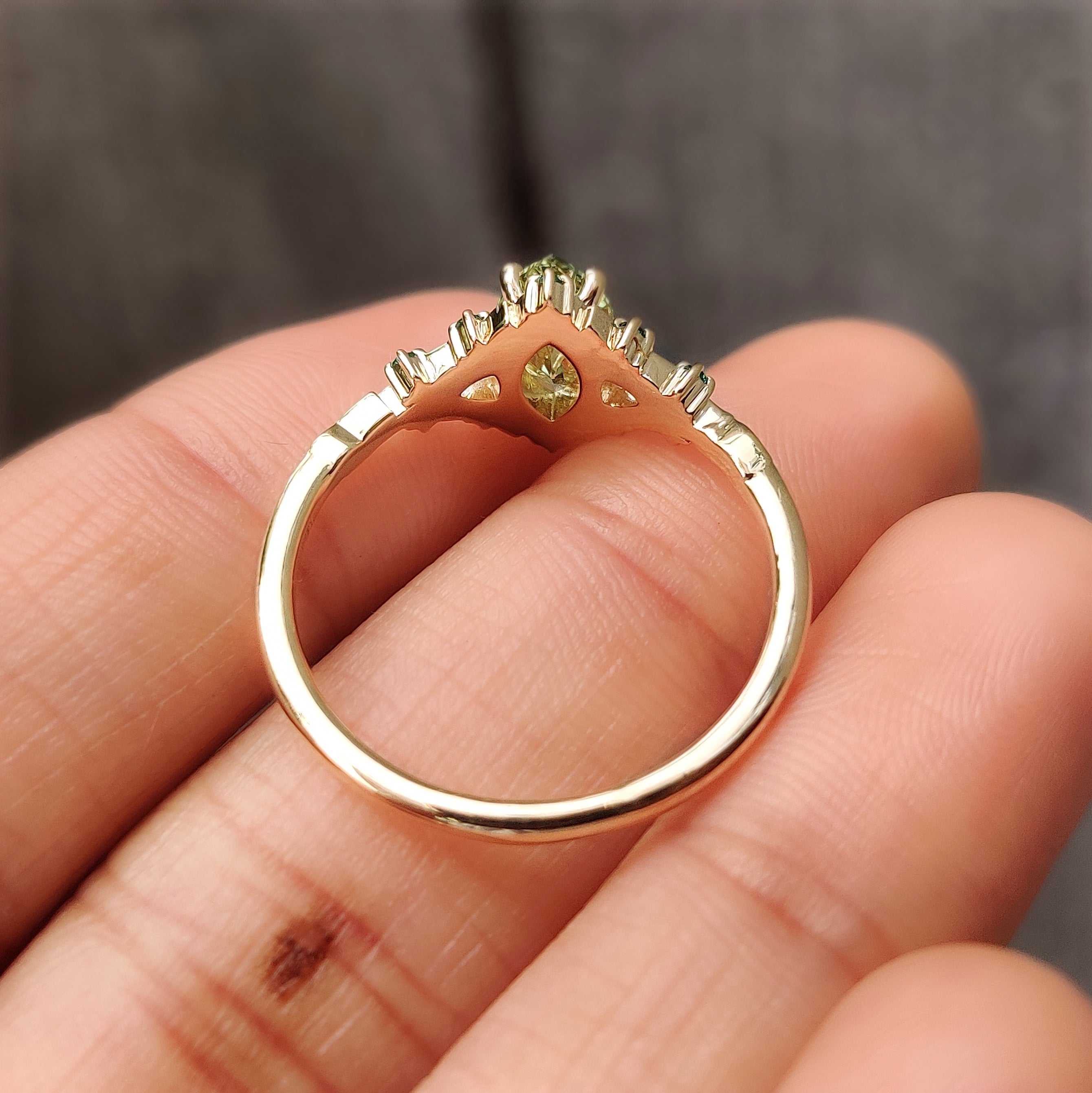 Rounded prong green marquise cluster ring.
