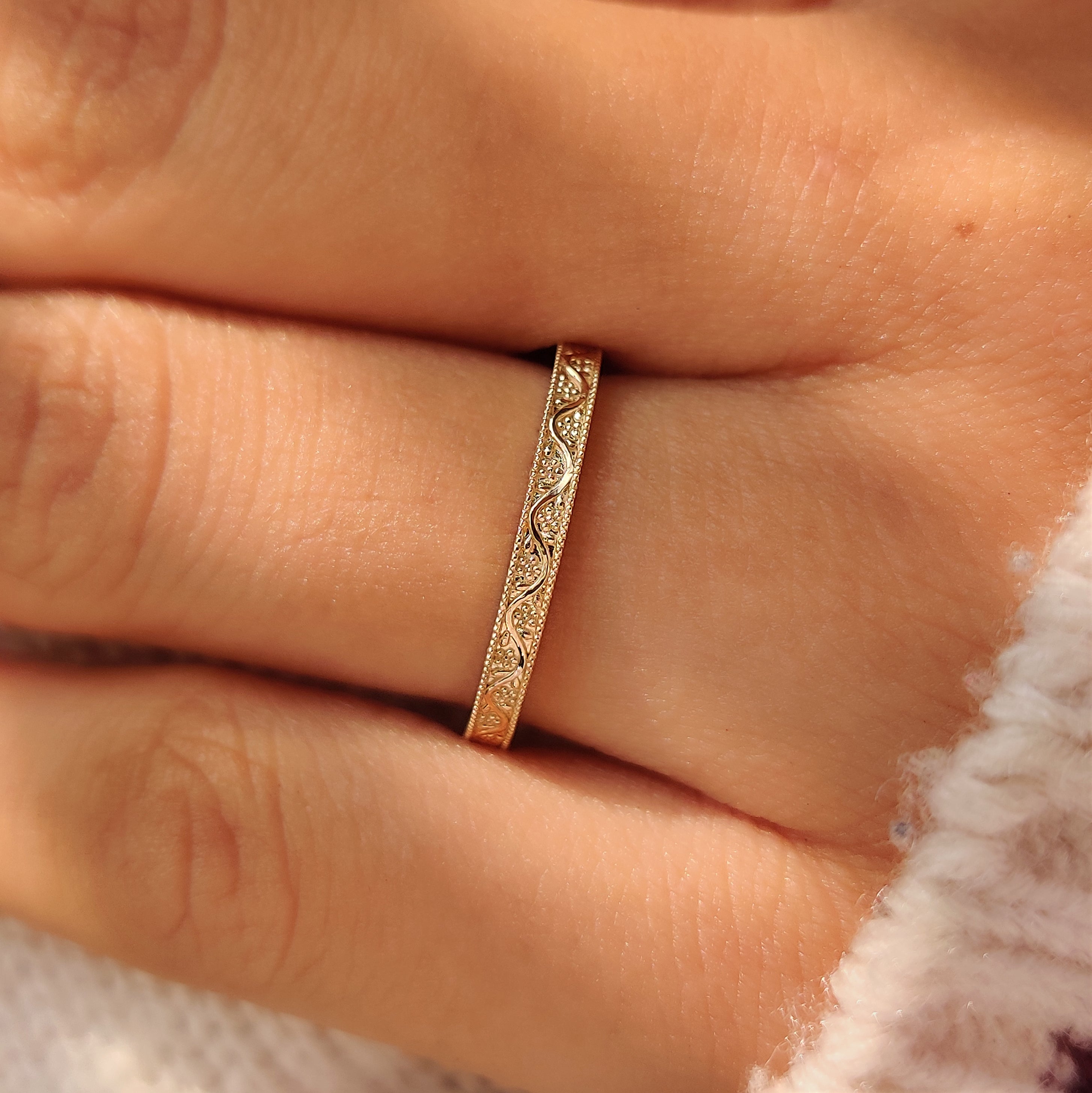 Yellow gold hand engraved floral details on a wedding band.
