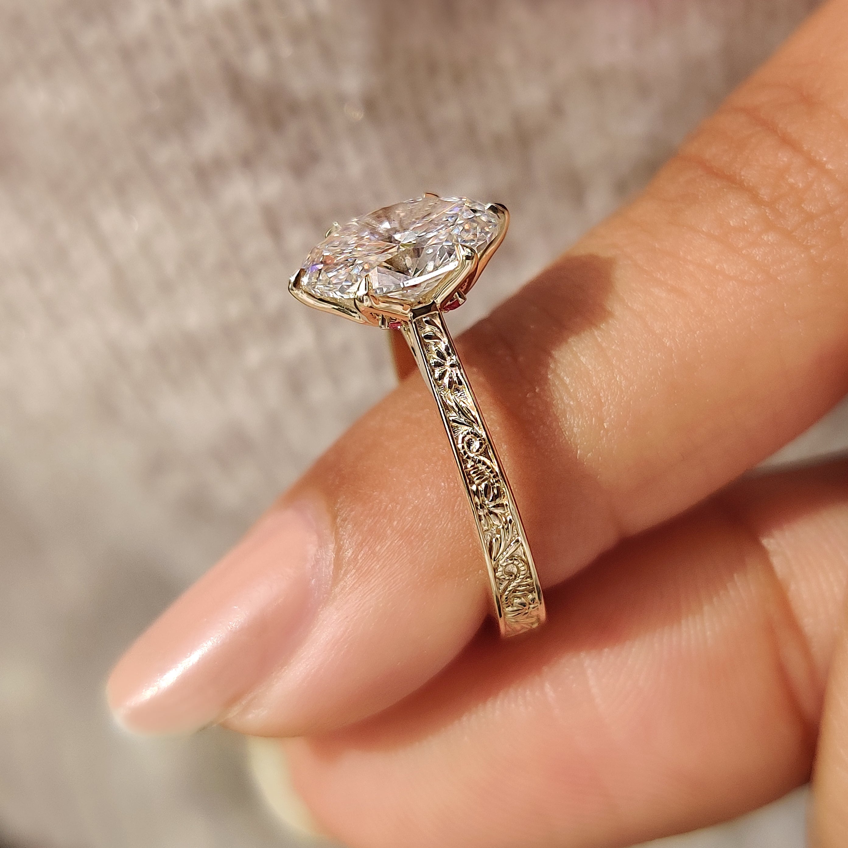 Oval diamond ring with hidden ruby and engraved accents
