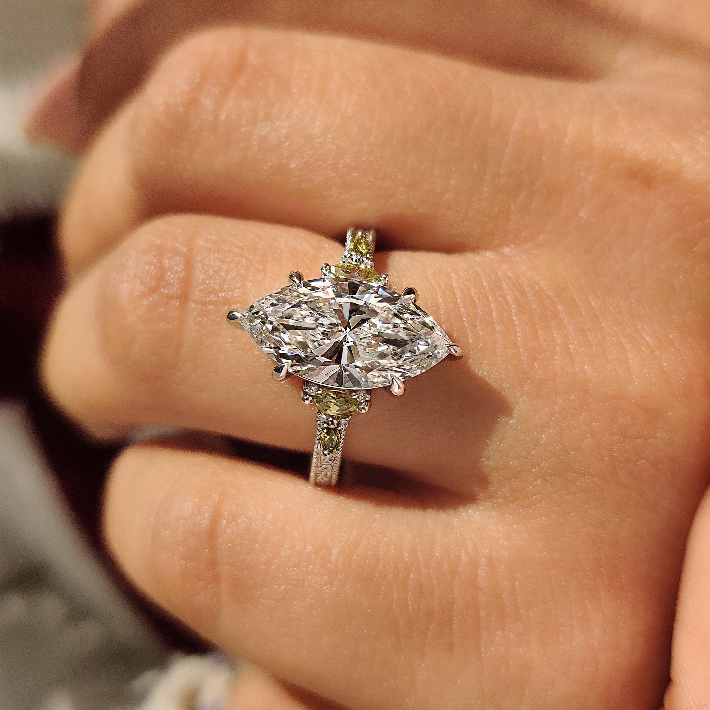 Six claw prong marquise ring with side stone accents
