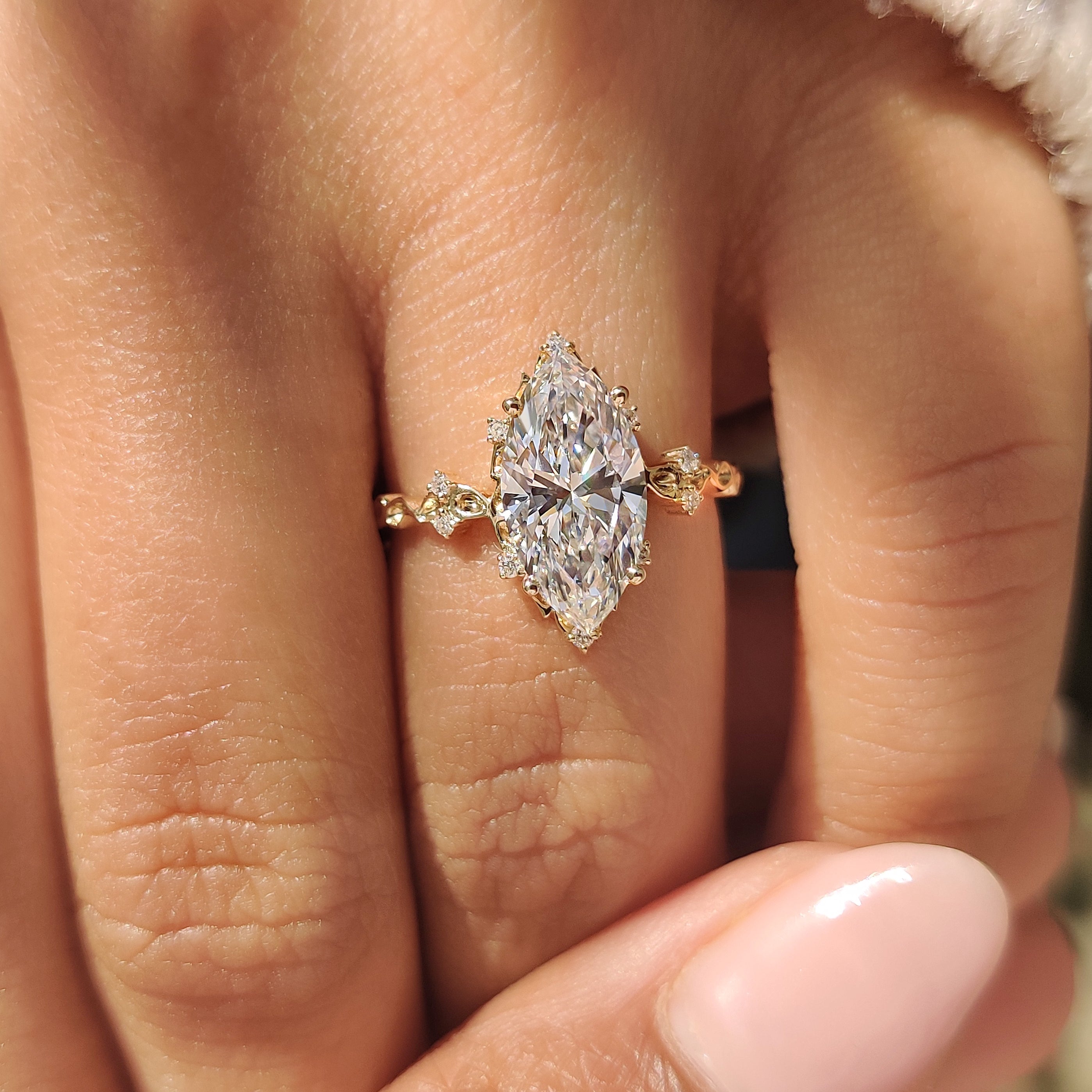 Marquise diamond ring with round accents and cluster setting.

