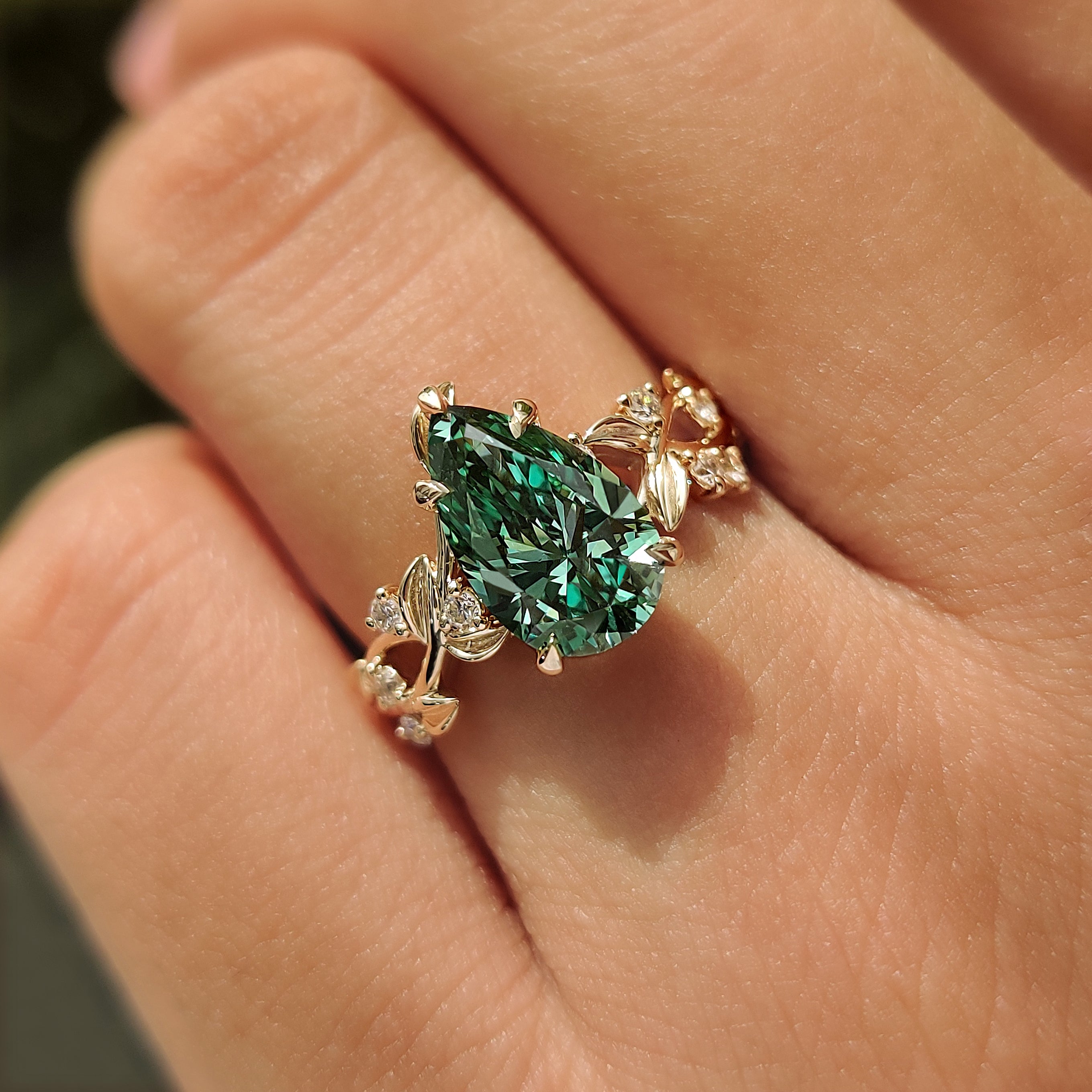 Nature inspired green pear shaped diamond with five claw prong.
