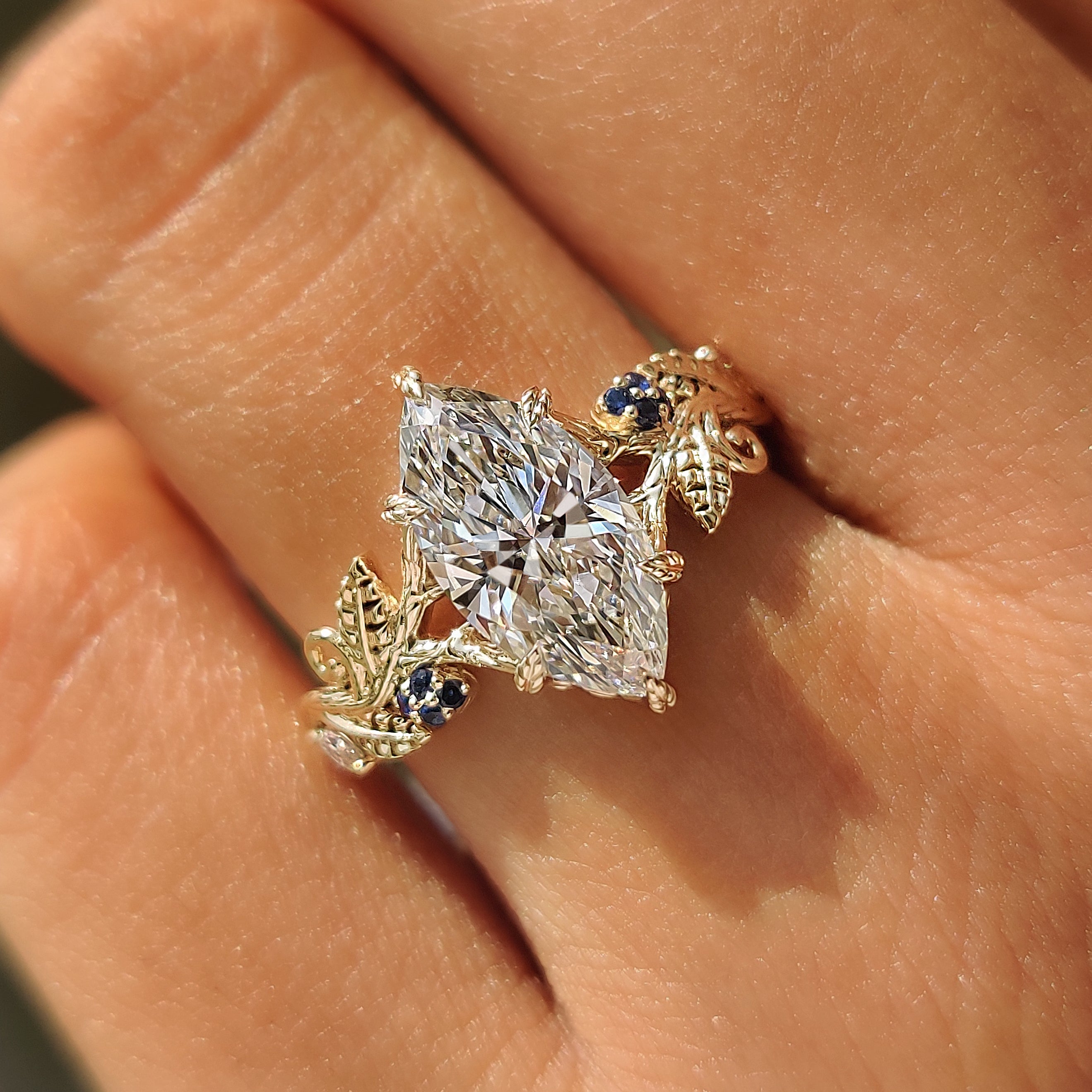 Marquise cut center diamond with blue sapphire side stones.