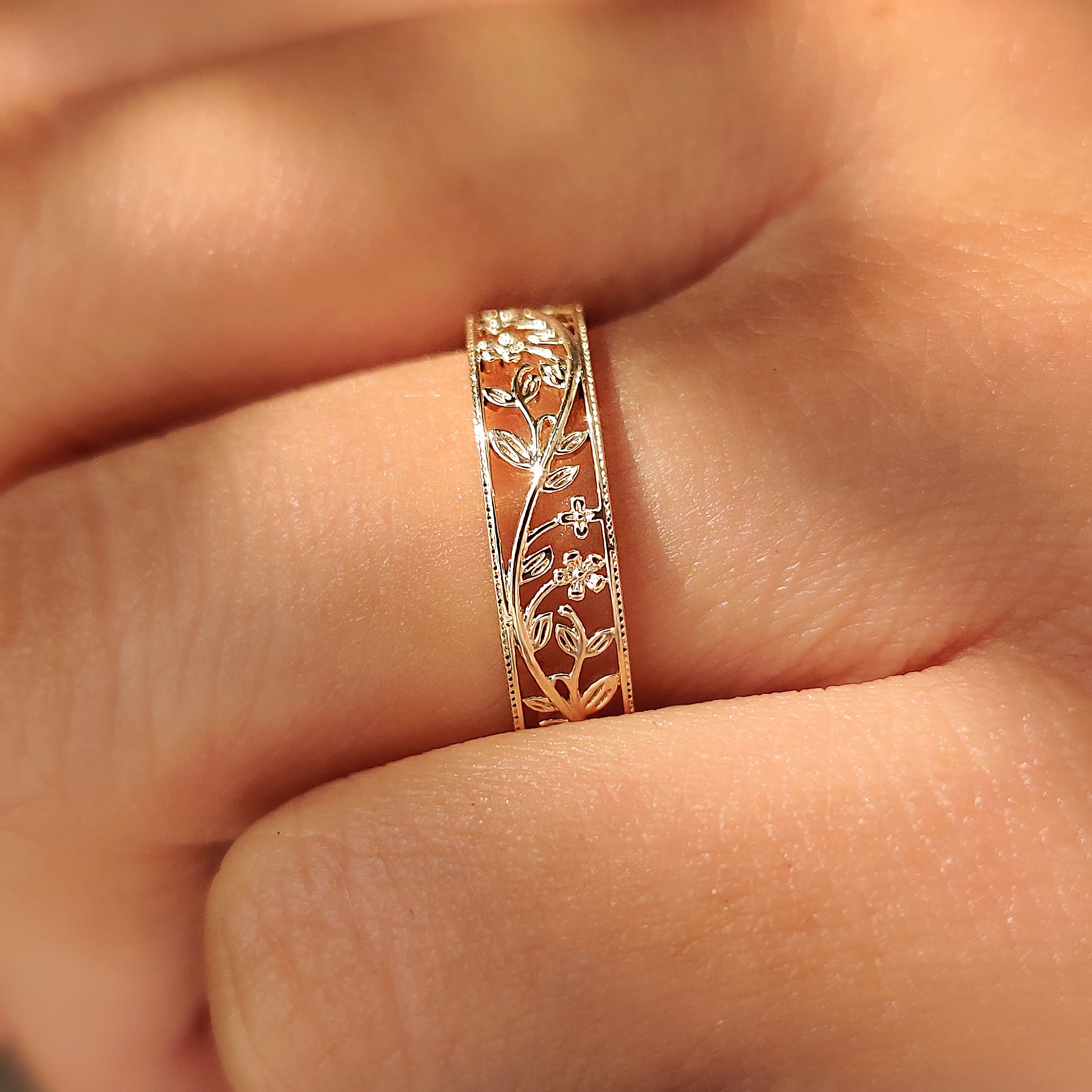 Leaf and vine design winding across a flower wedding band.
