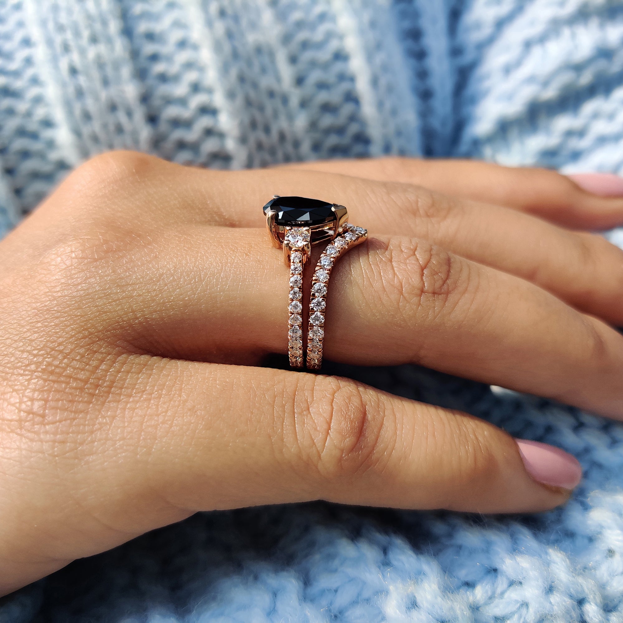 Round side stone ring paired with a pear cut center in a Moissanite bridal set.
