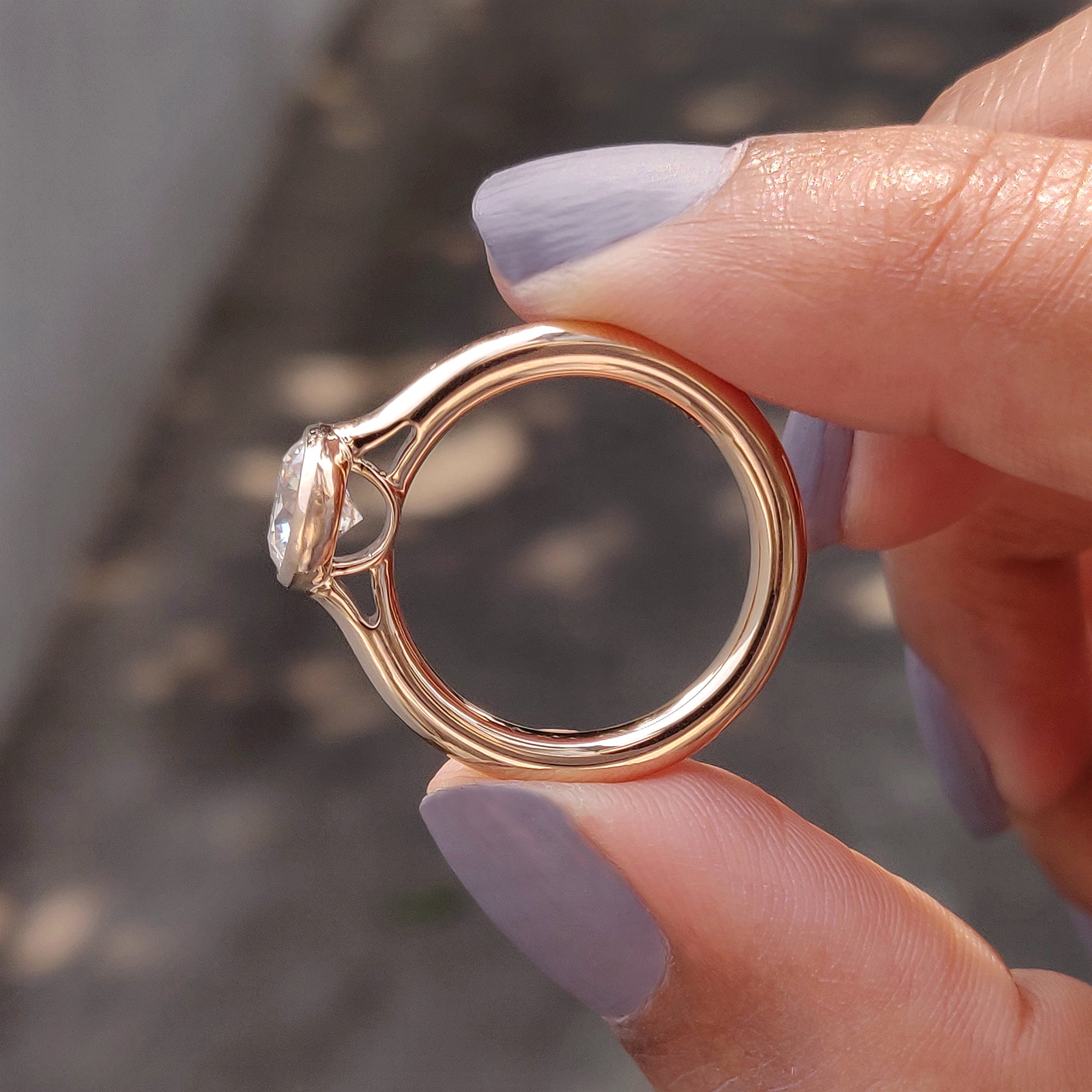 Rose gold engagement ring with round bezel design.